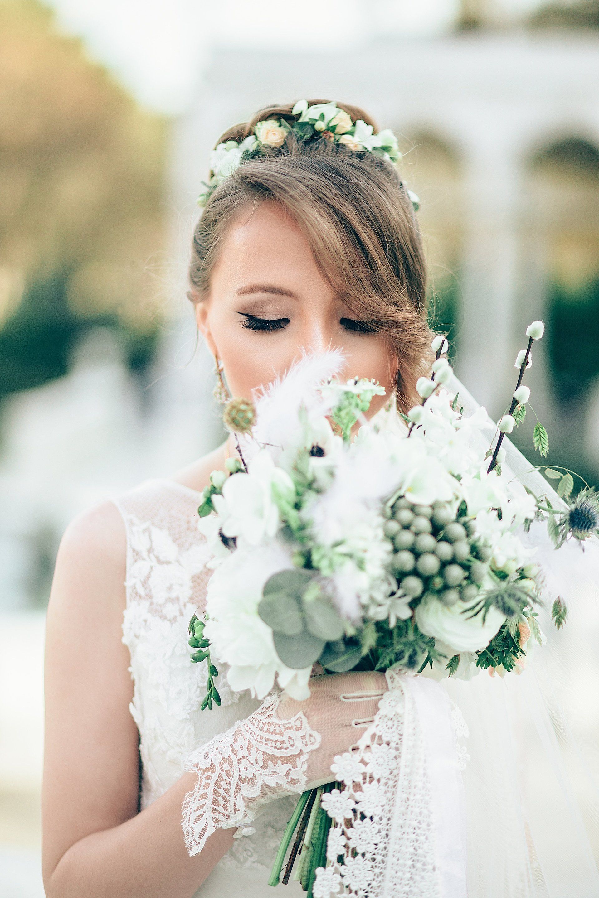 The bride is wearing a flower crown and holding a bouquet of white flowers.