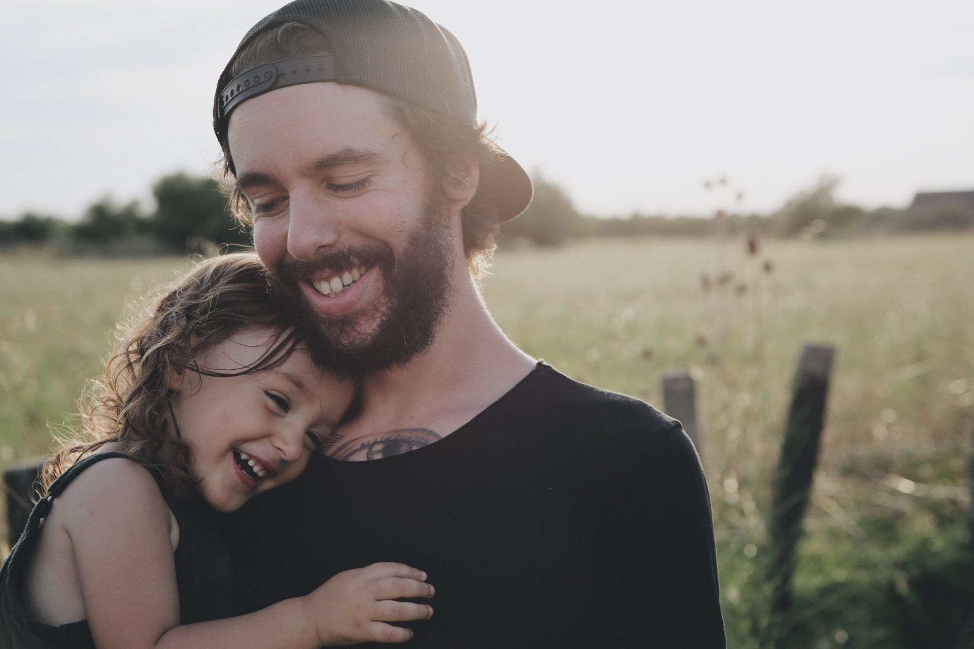 father carries young daughter