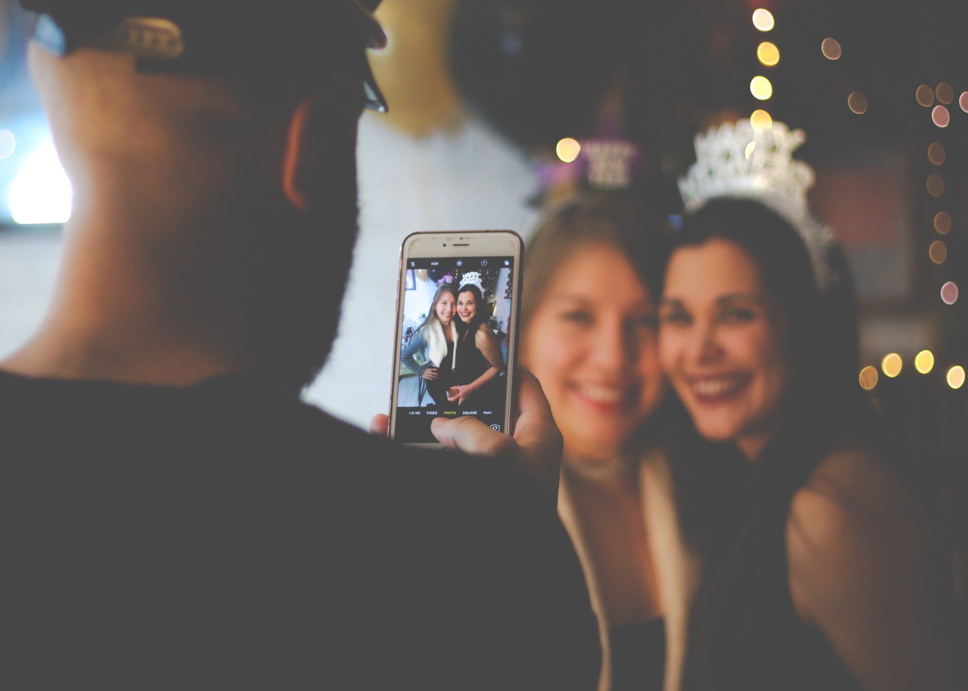 Un uomo scatta una foto a due donne con un cellulare