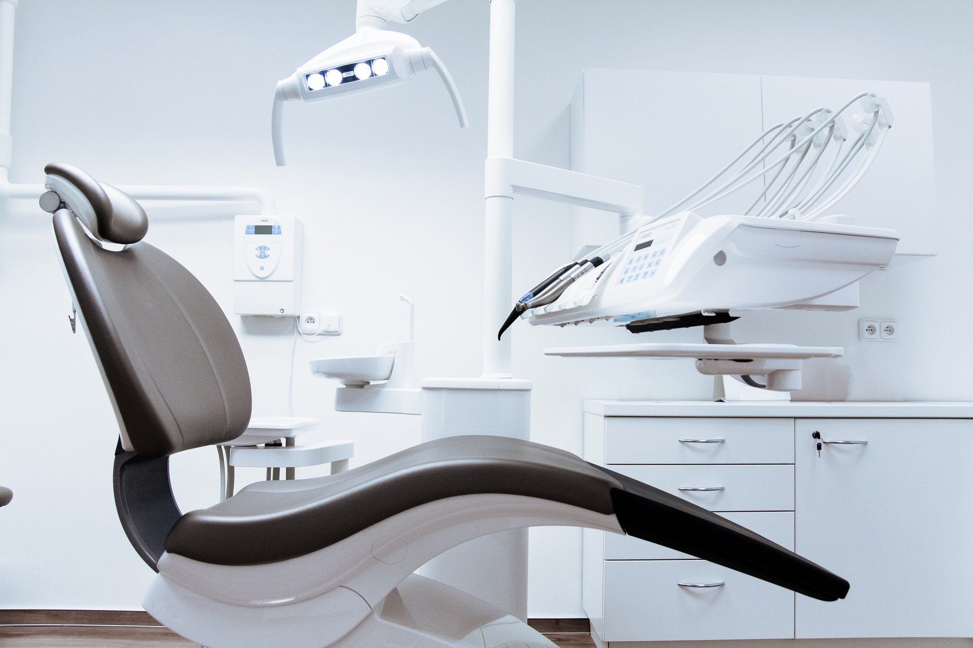 Modern dental chair in a bright, sterile examination room.