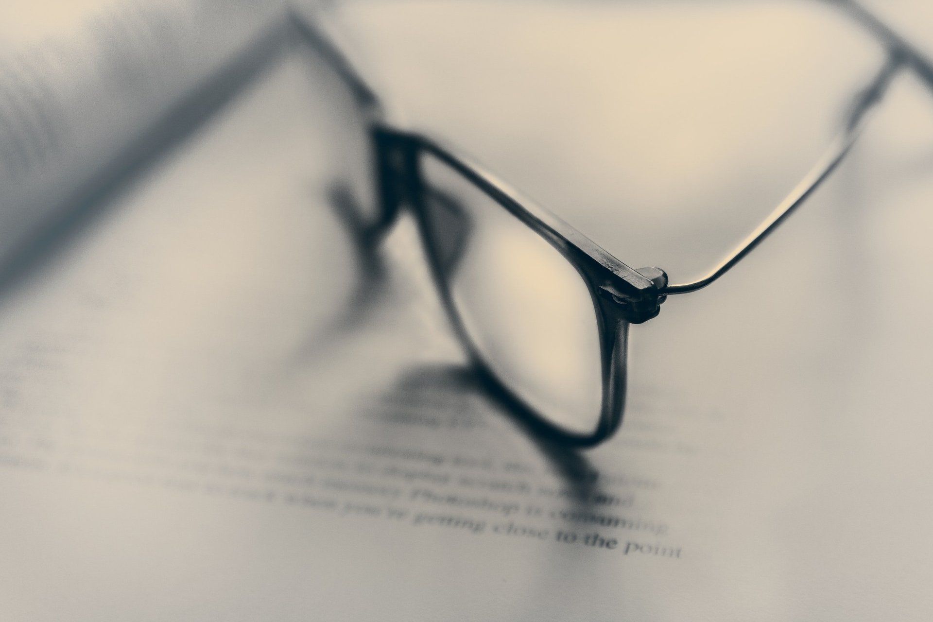 A pair of glasses sitting on top of a book