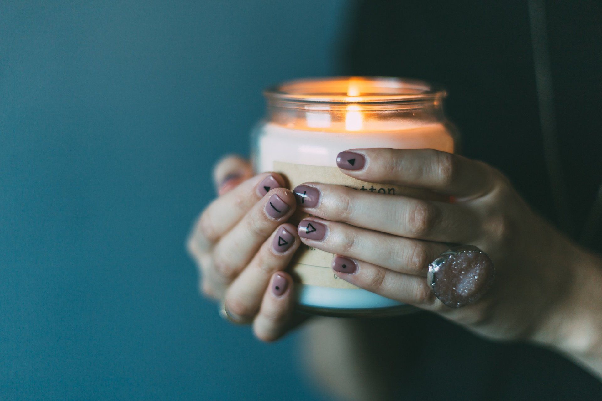 A woman is holding a candle in her hands.