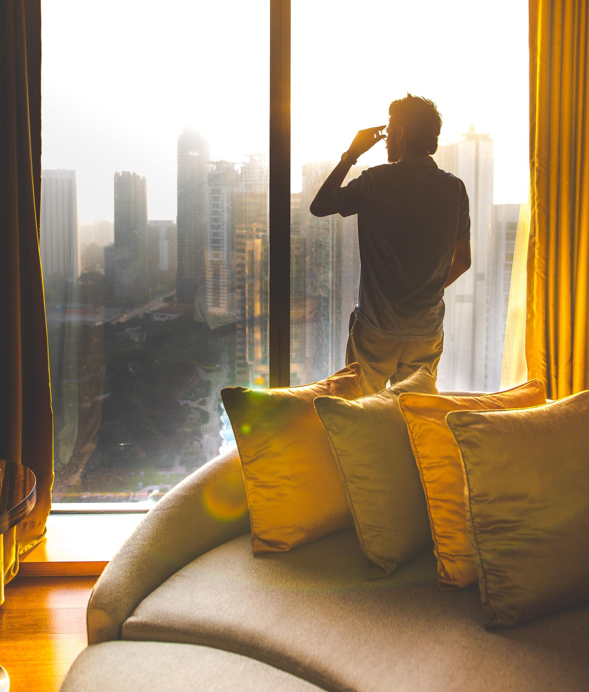 A man standing in front of a window looking out