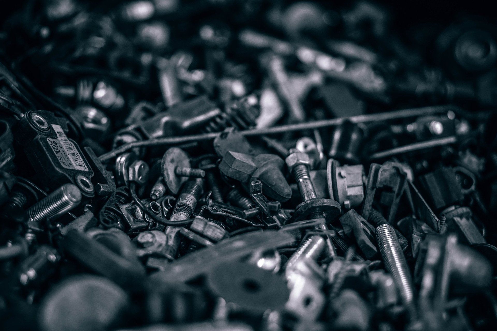 A black and white photo of a pile of nuts and bolts.