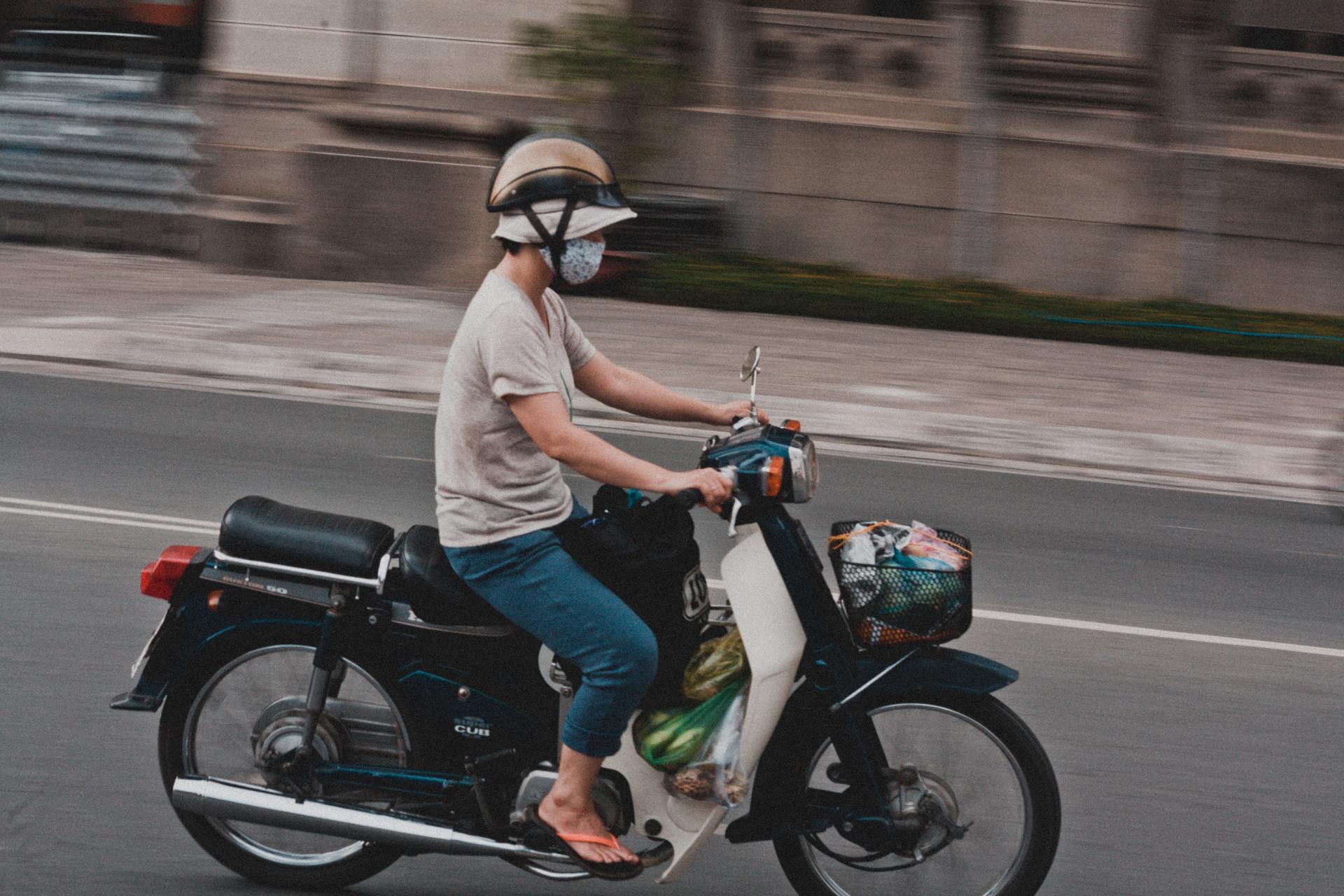 A person is riding a motorcycle down a street.