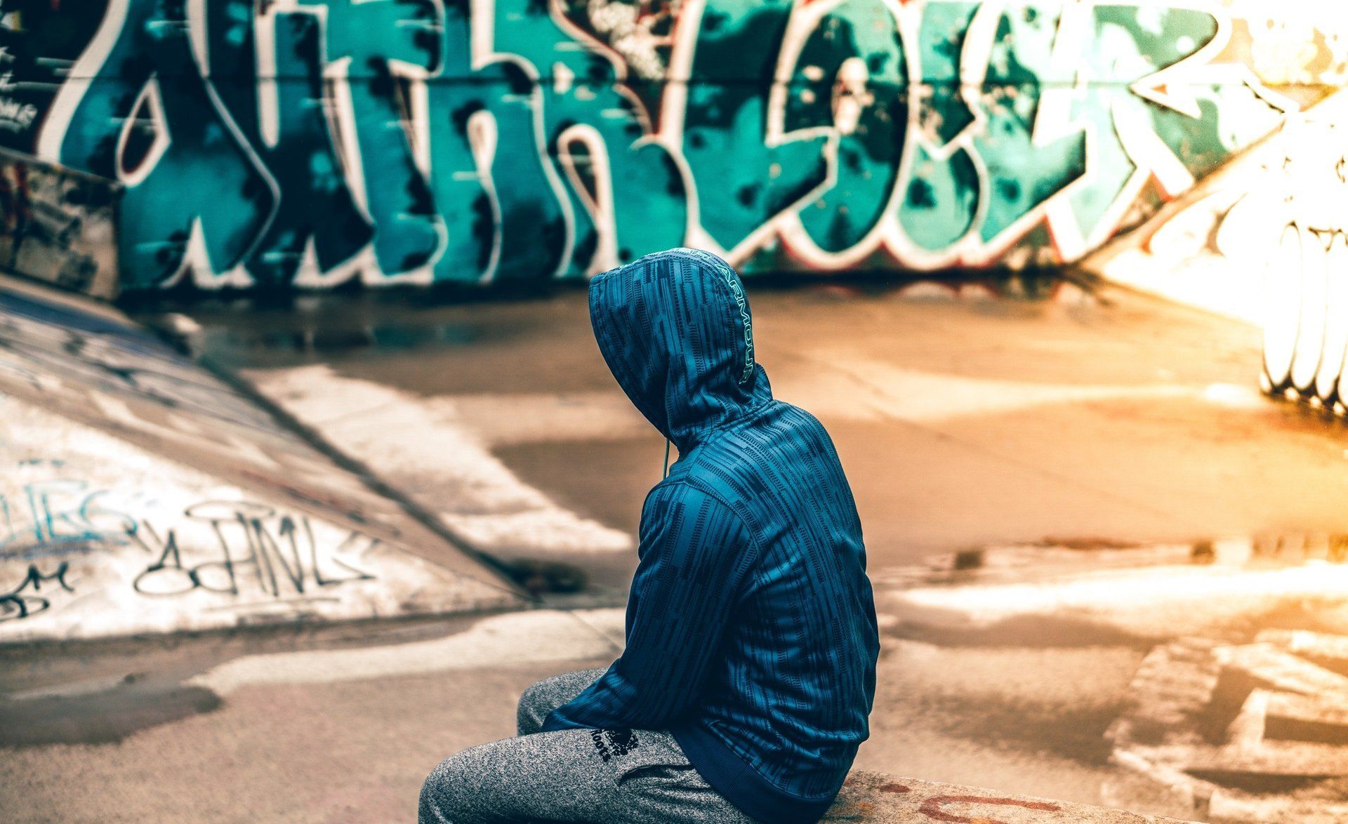 young female women in black turtleneck with arms crossed standing in front of a graffiti wall