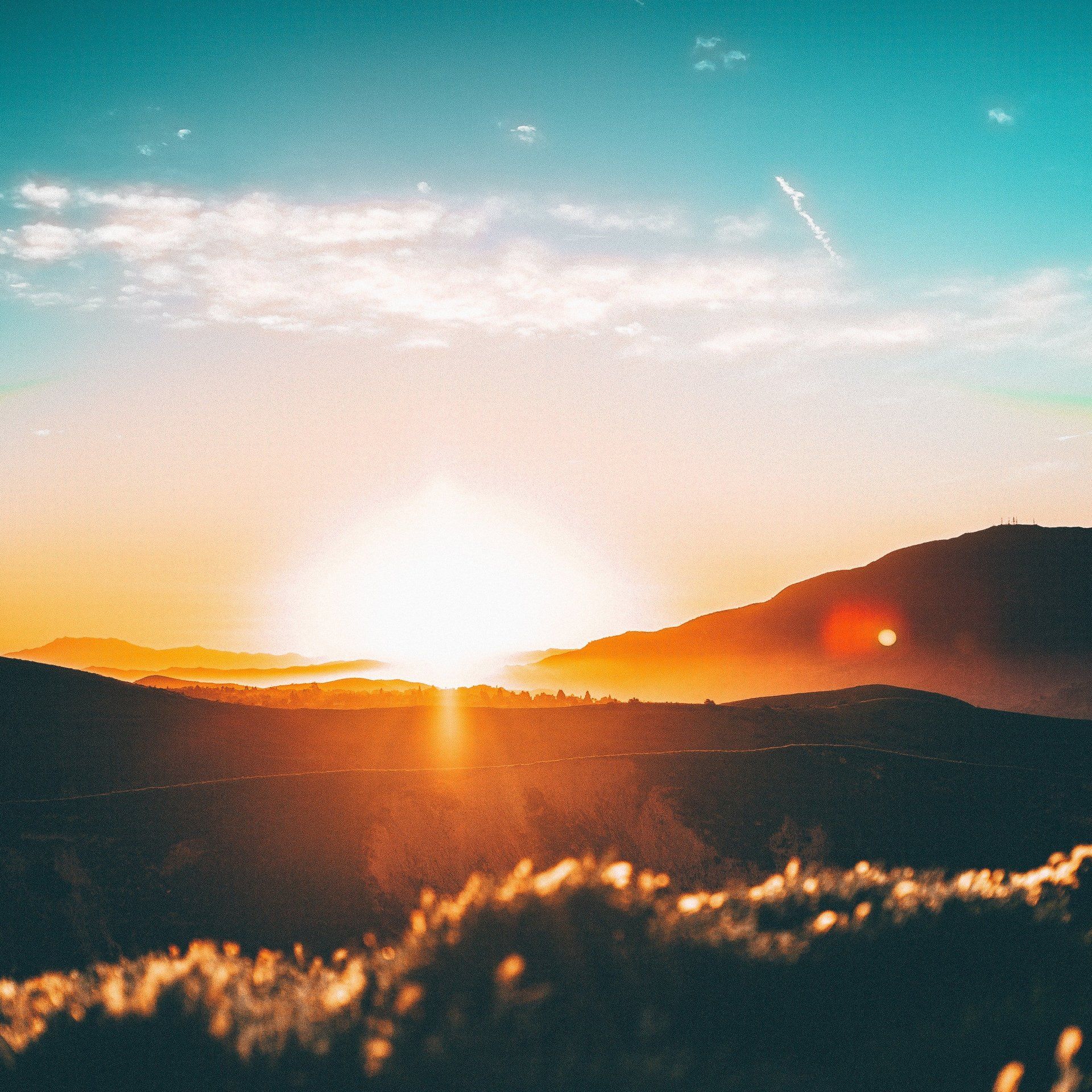 The sun is setting over the mountains in the distance