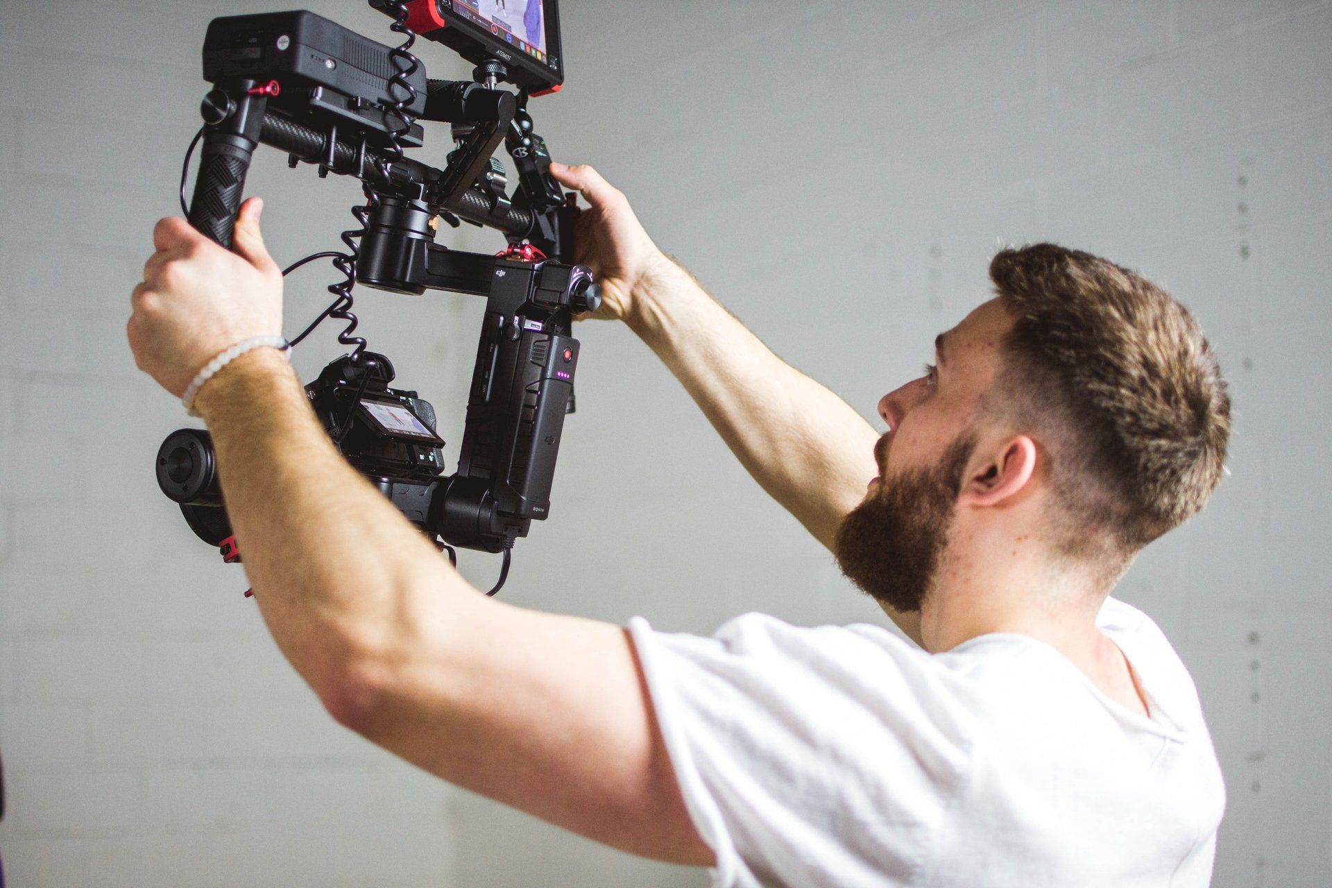 A man in a white shirt is working on a camera