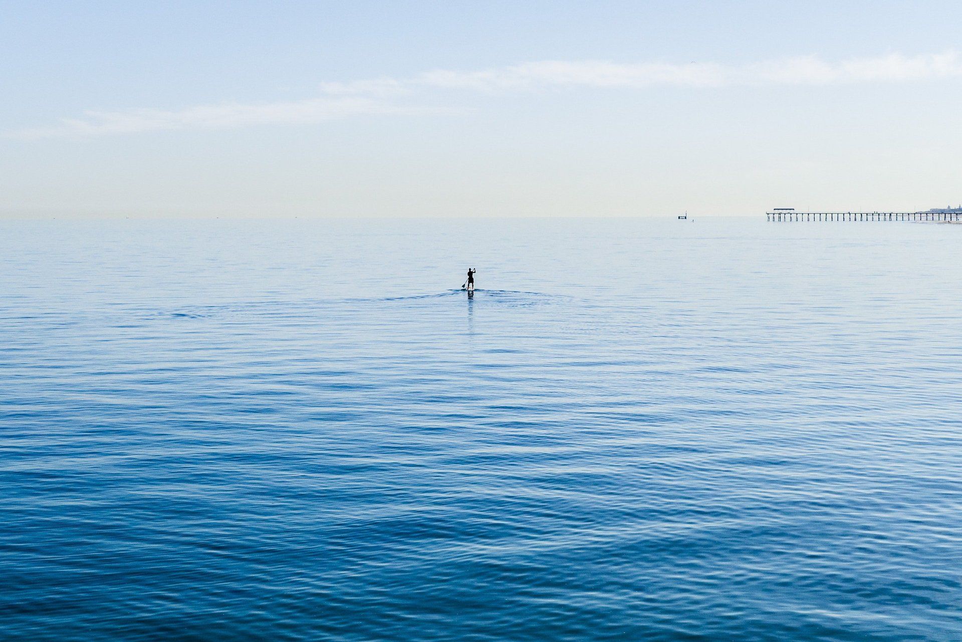 A person is standing in the middle of a large body of water.