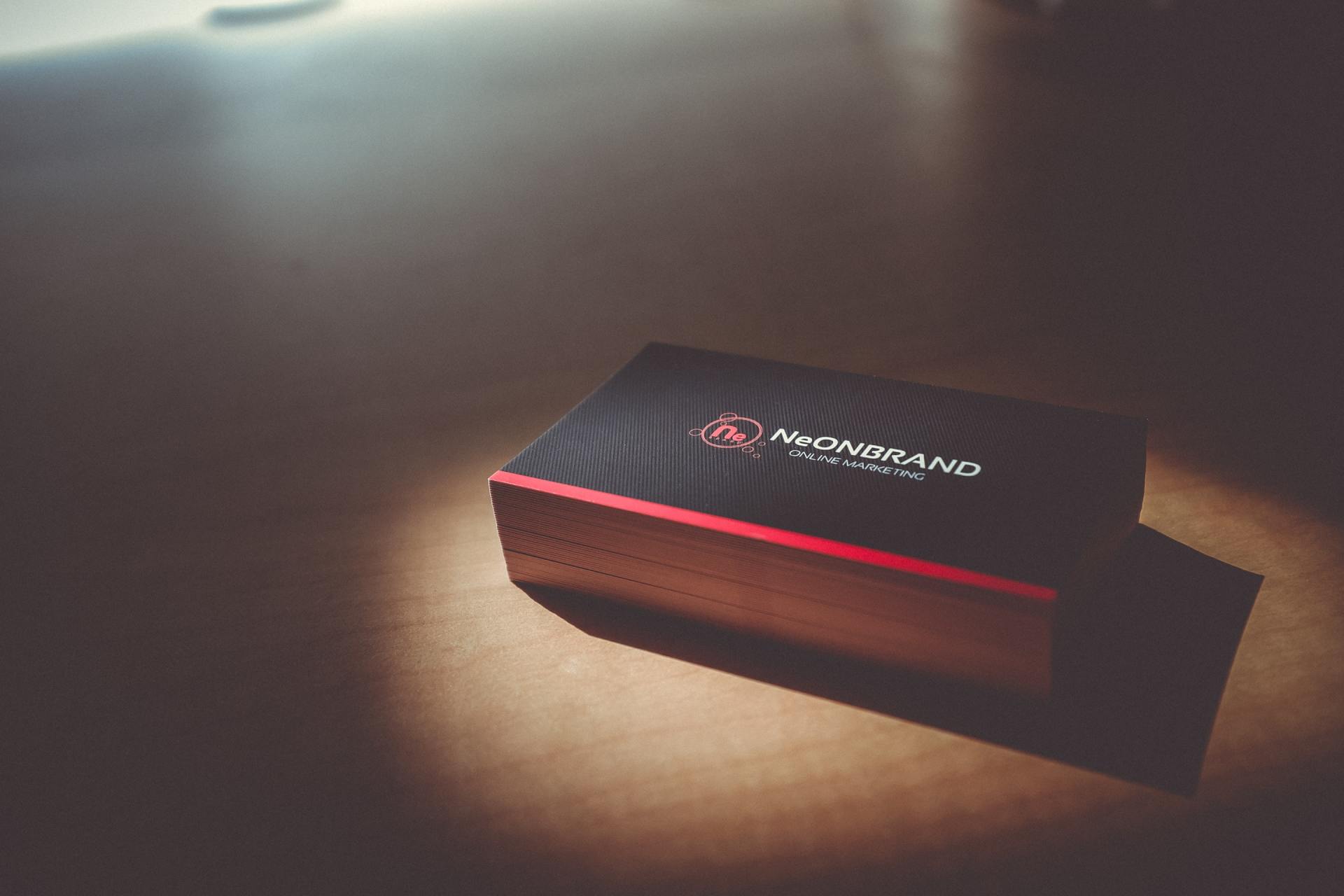 dark coloured business cards stacked on wooden desk