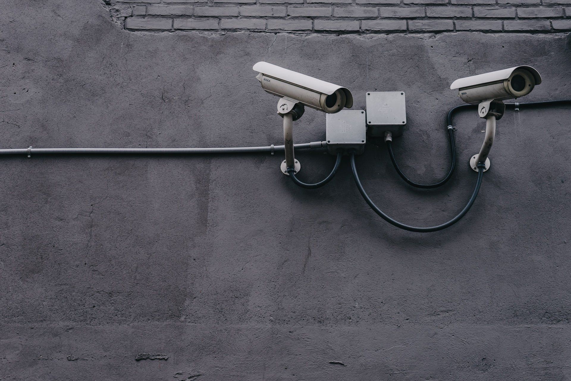 Two security cameras are mounted on the side of a building.
