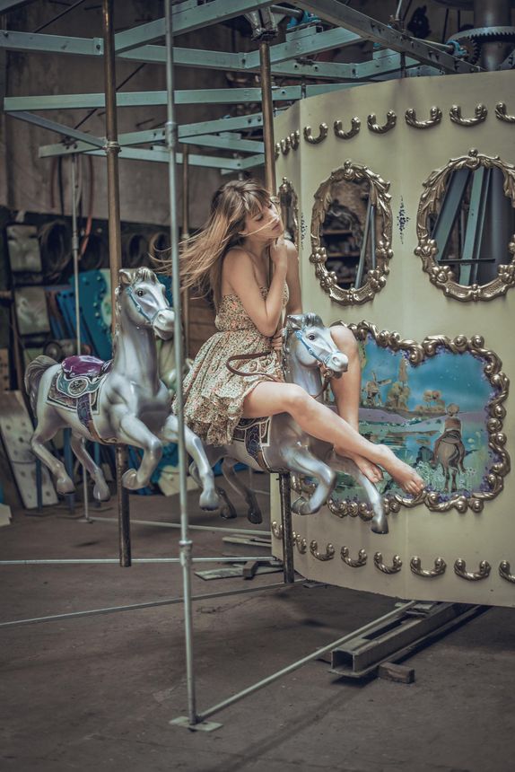 Woman on a carousel horse in an old indoor amusement setting