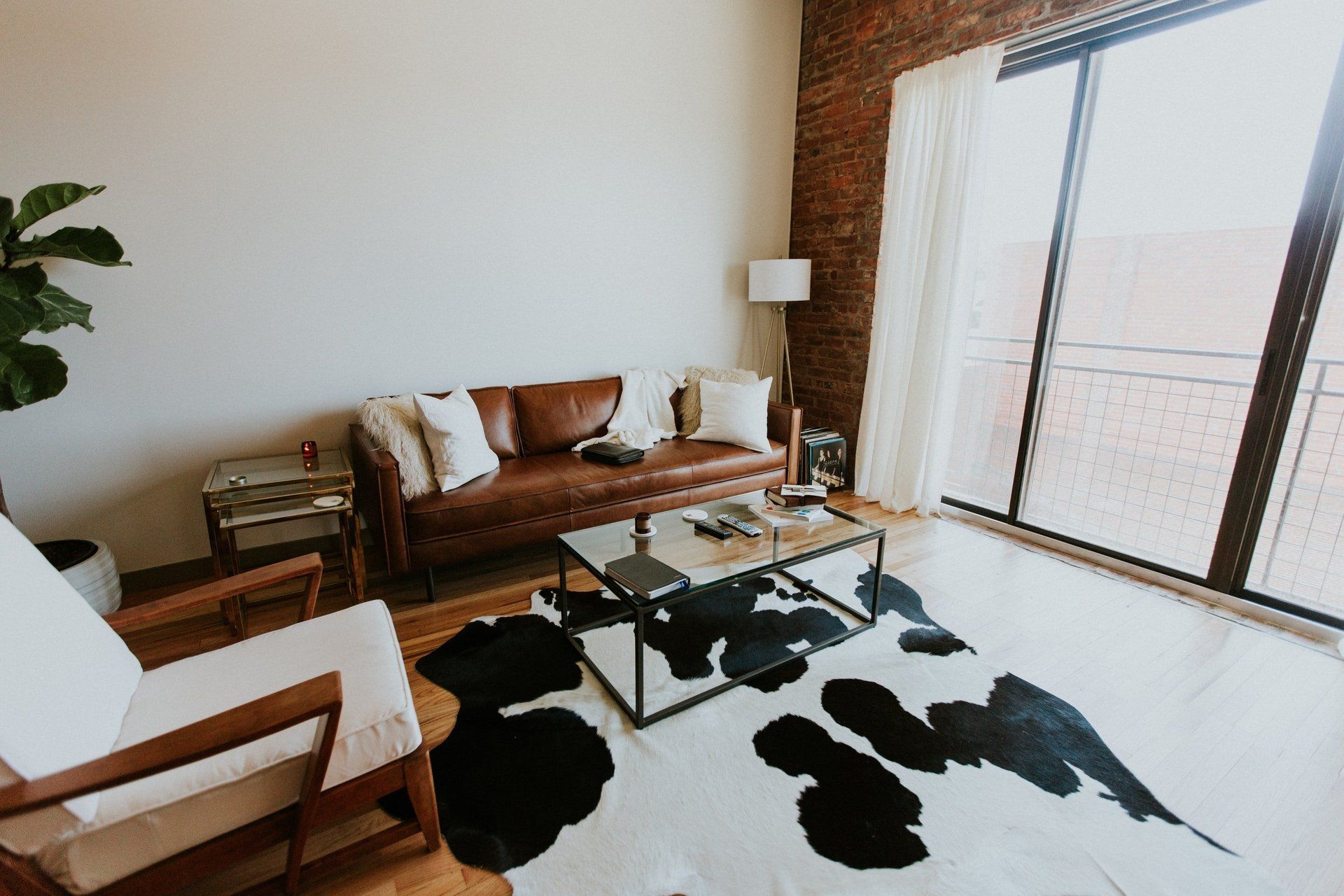A living room with a couch , chair , coffee table and rug.