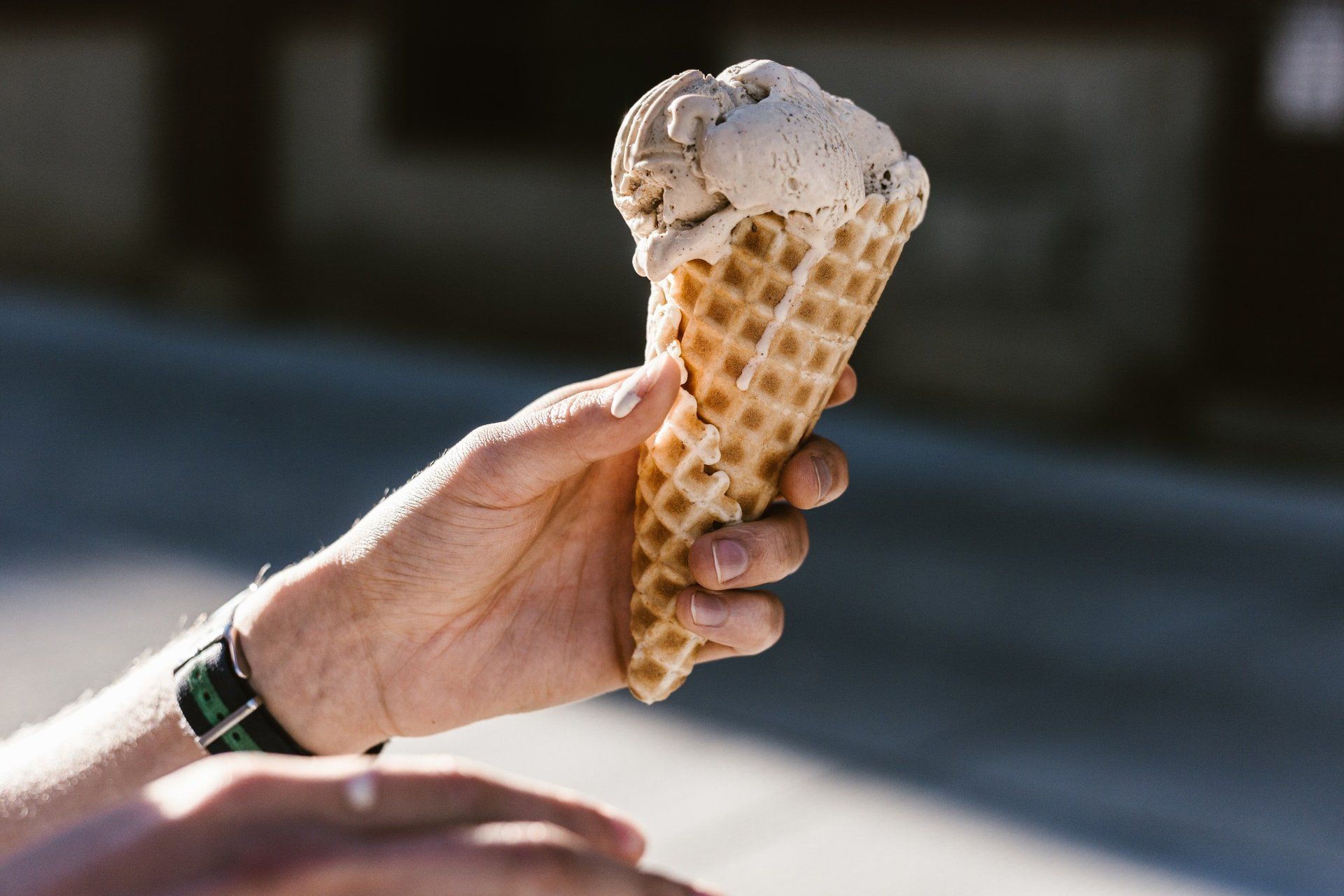 A person is holding an ice cream cone in their hand.