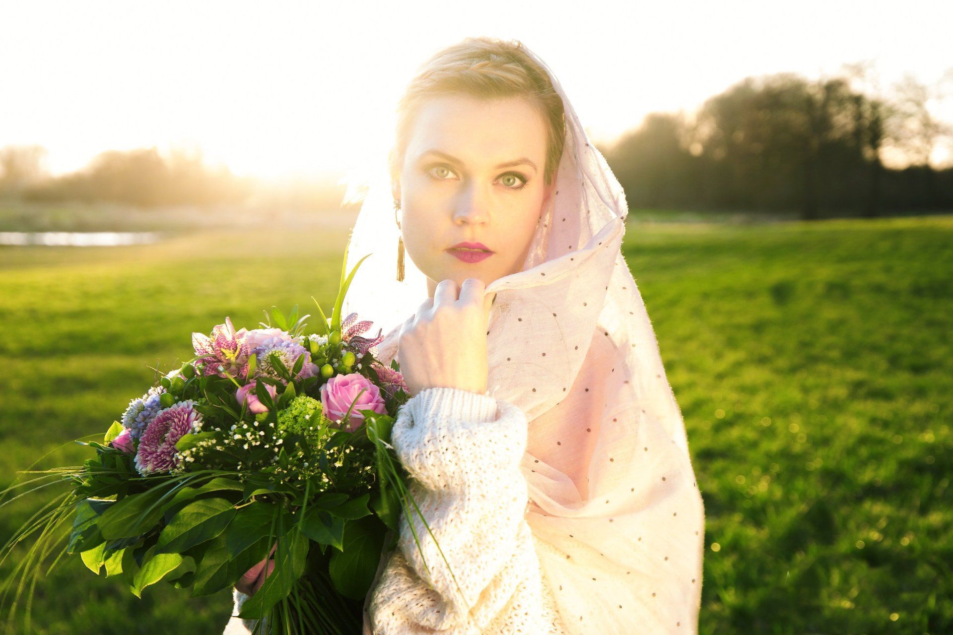 Eine Frau hält auf einem Feld einen Blumenstrauß.