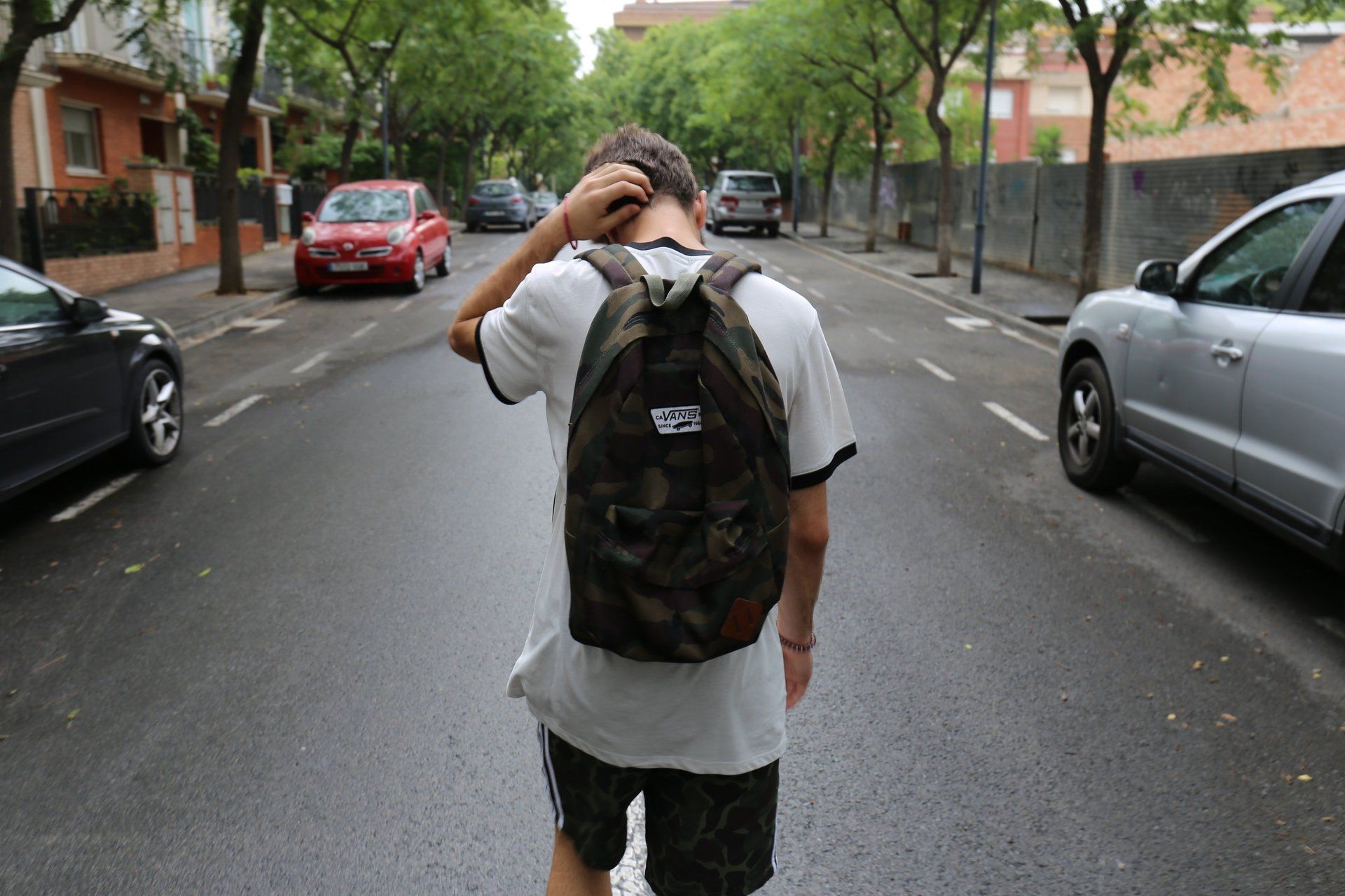 Un uomo con uno zaino cammina per strada