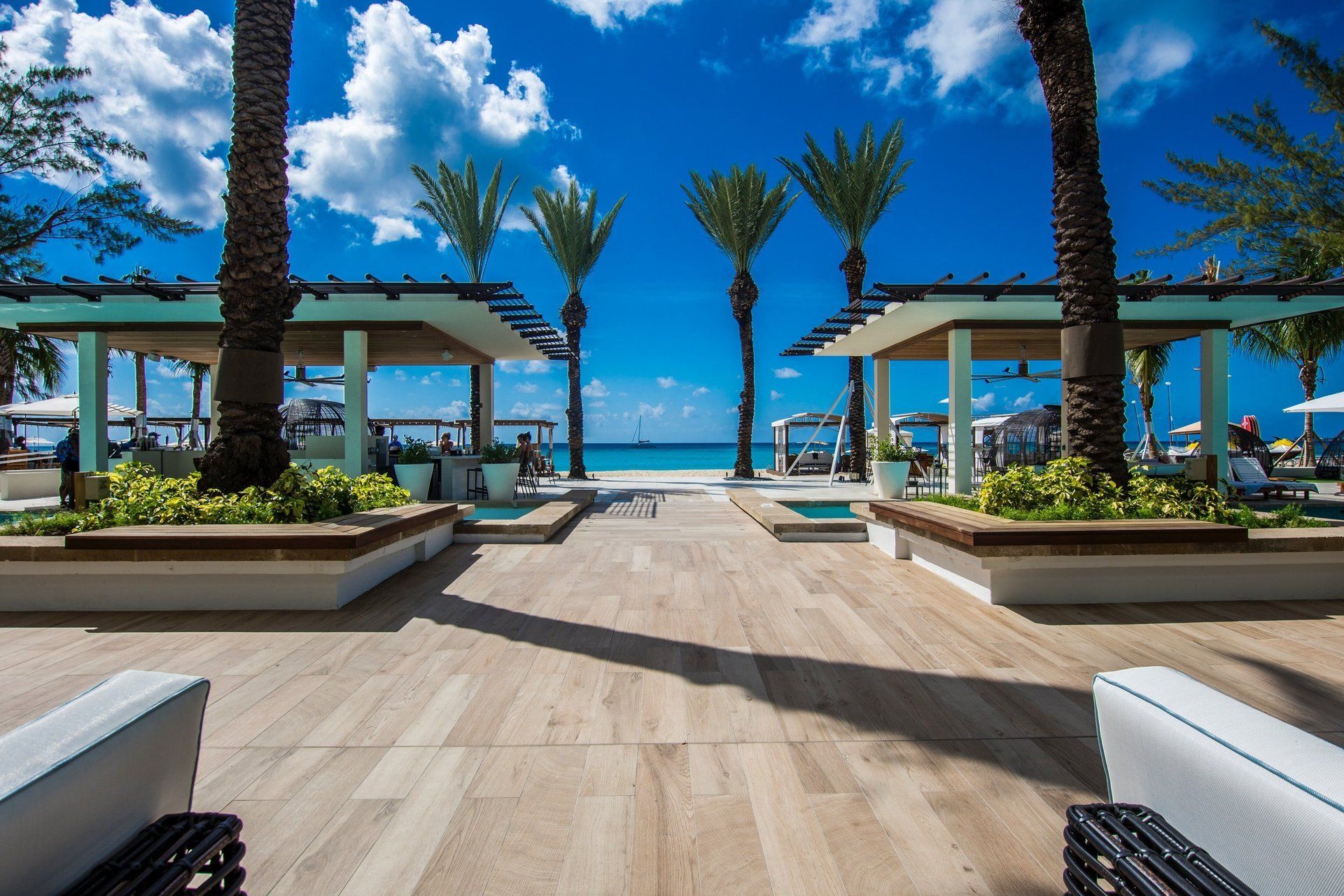 A view of a beach resort with palm trees and a swimming pool