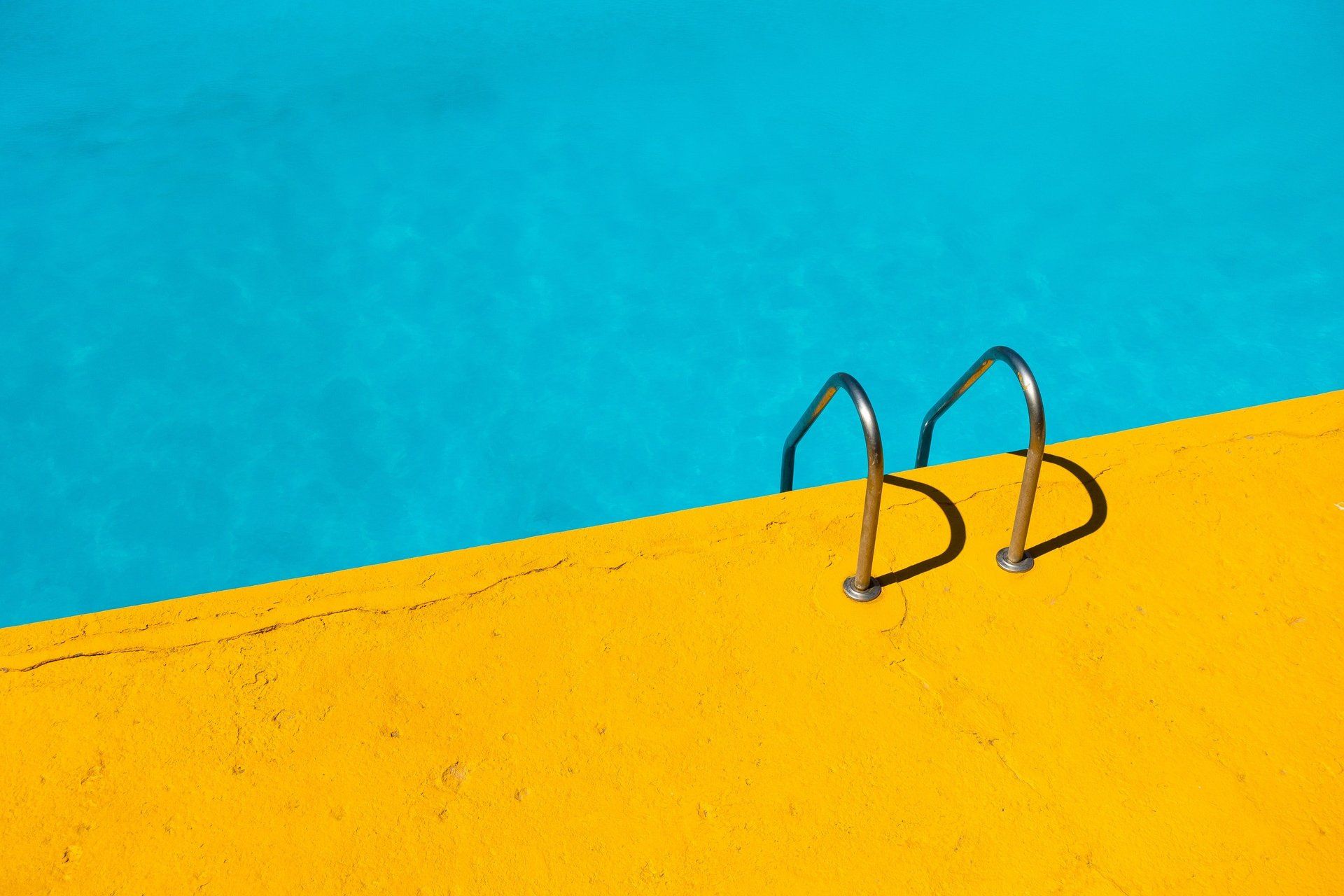 A pair of stairs leading into a swimming pool.