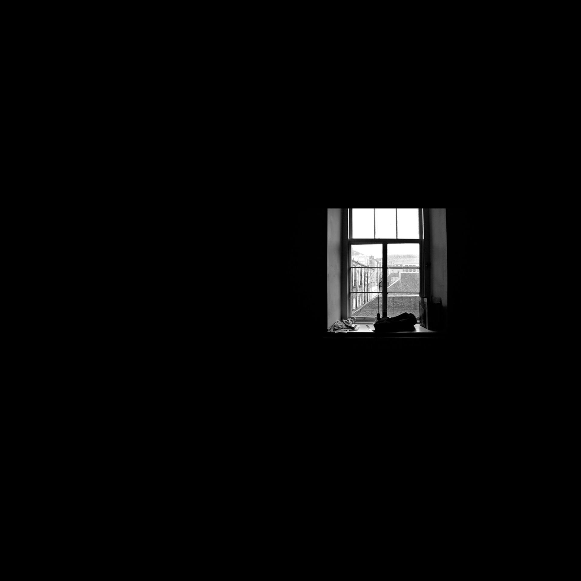 dark room with small window showing some light to the town outside