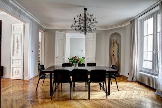 A dining room with a table and chairs and a chandelier.