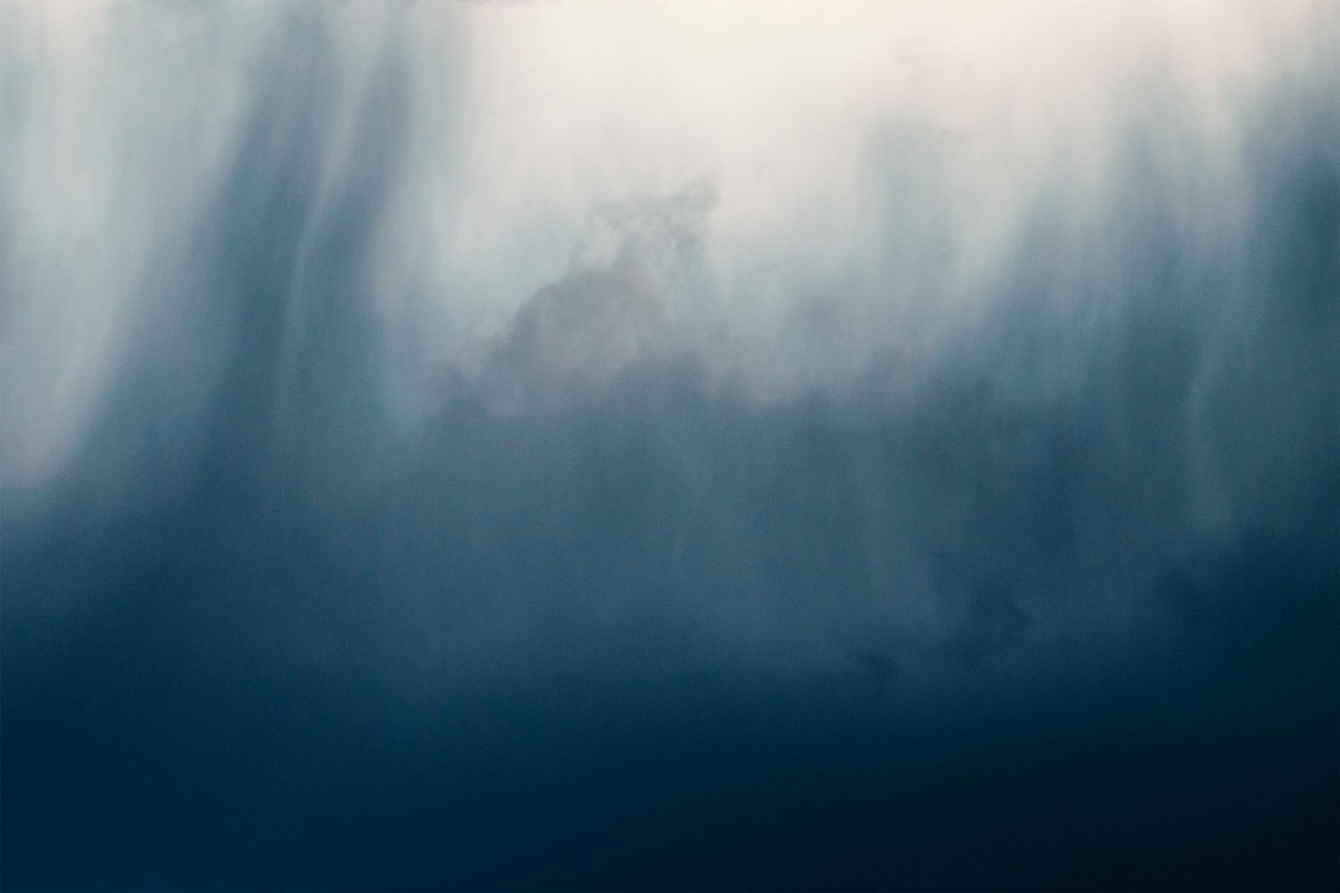The sun is shining through the clouds in the sky.