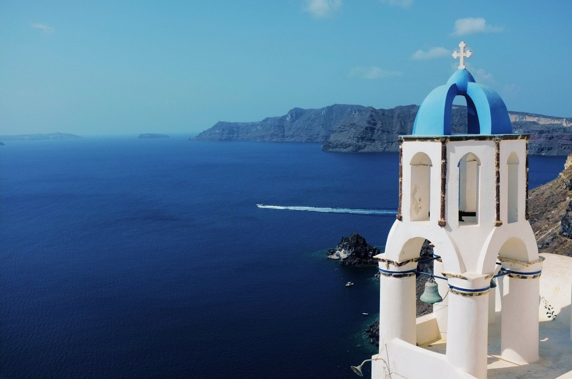 A bell tower with a blue dome in the middle of the ocean