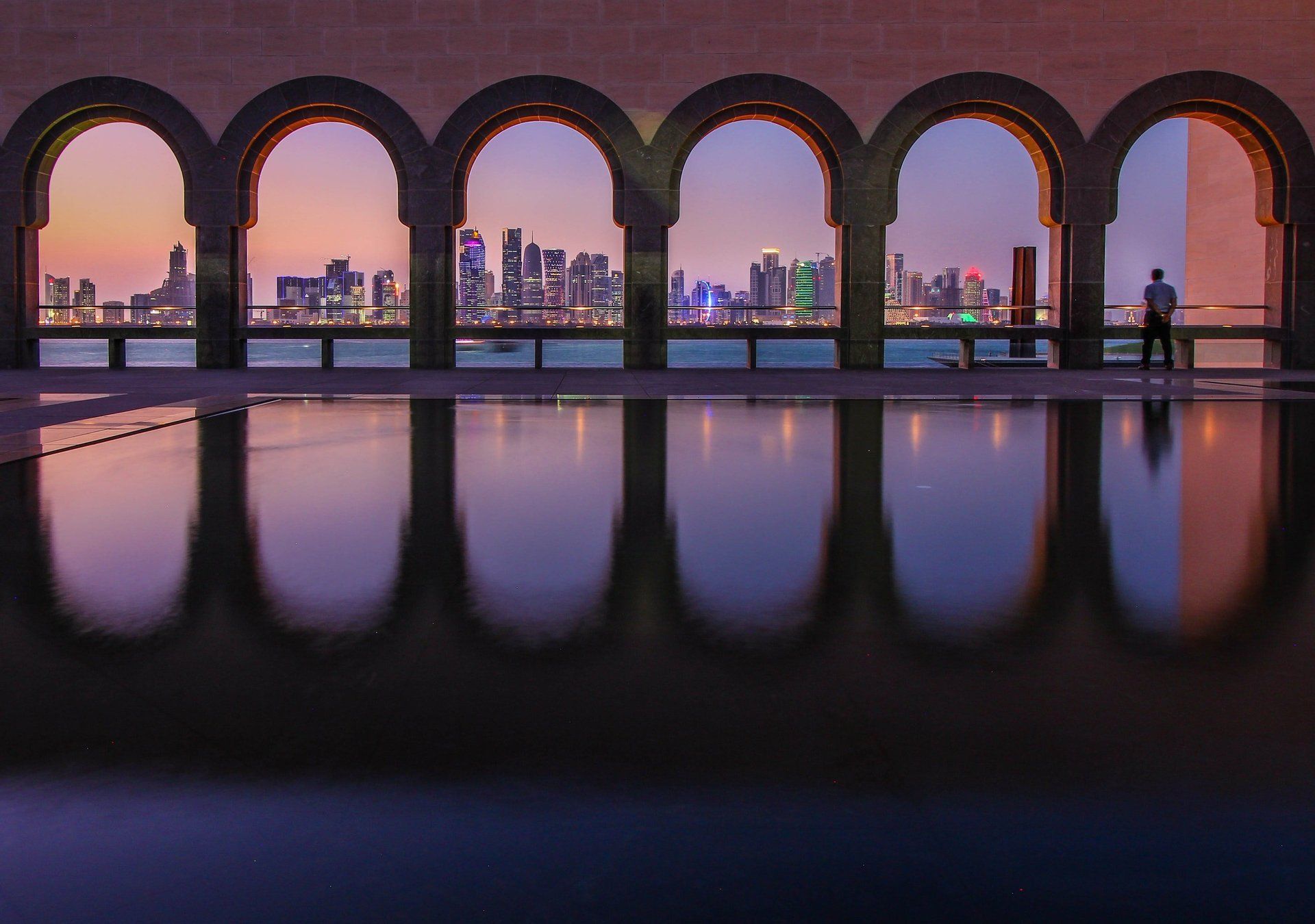 Die Skyline einer Stadt spiegelt sich in einem Wasserbecken