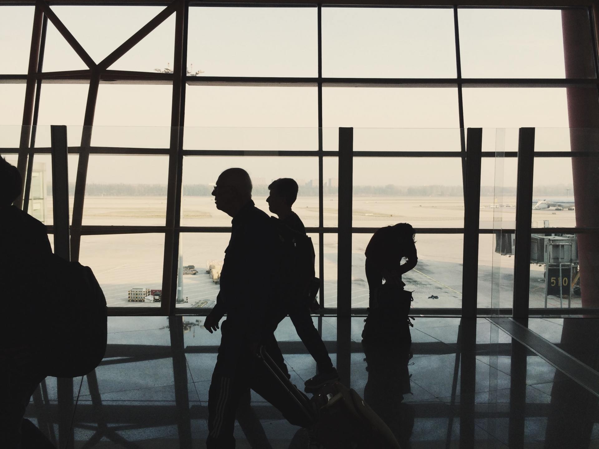 A group of people are walking through an airport with their luggage