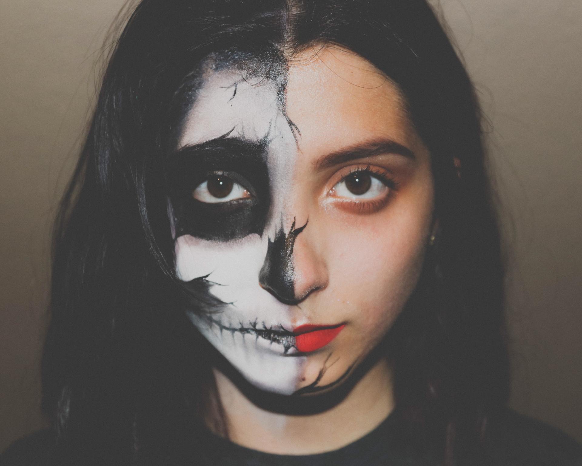 A woman with half of her face painted like a skeleton