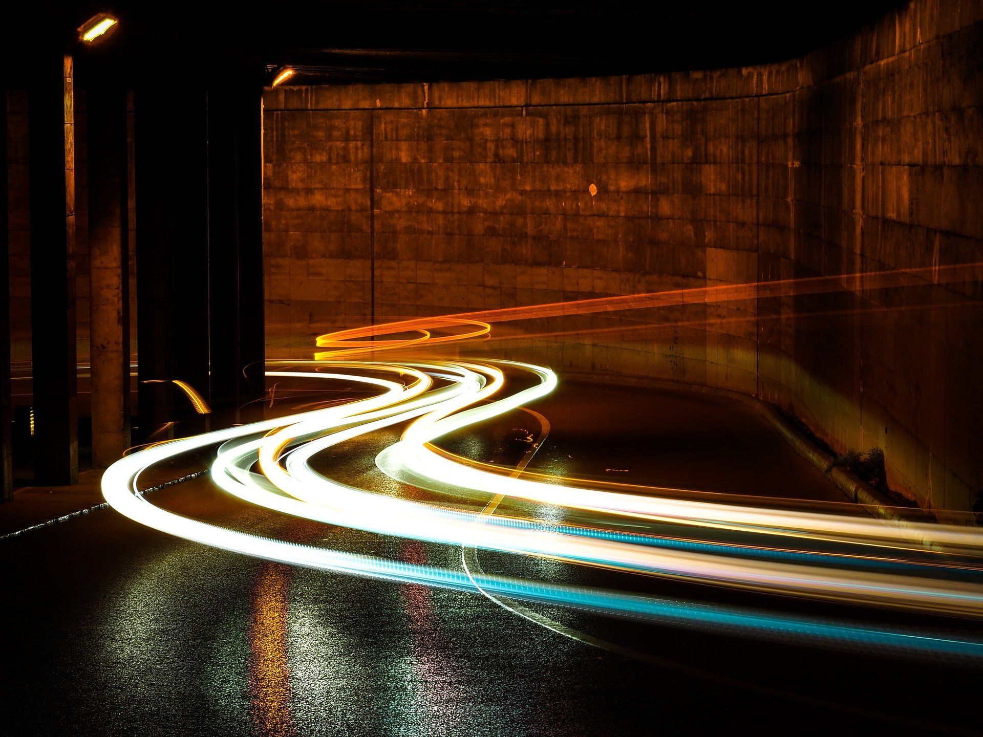 A car is driving through a tunnel at night.