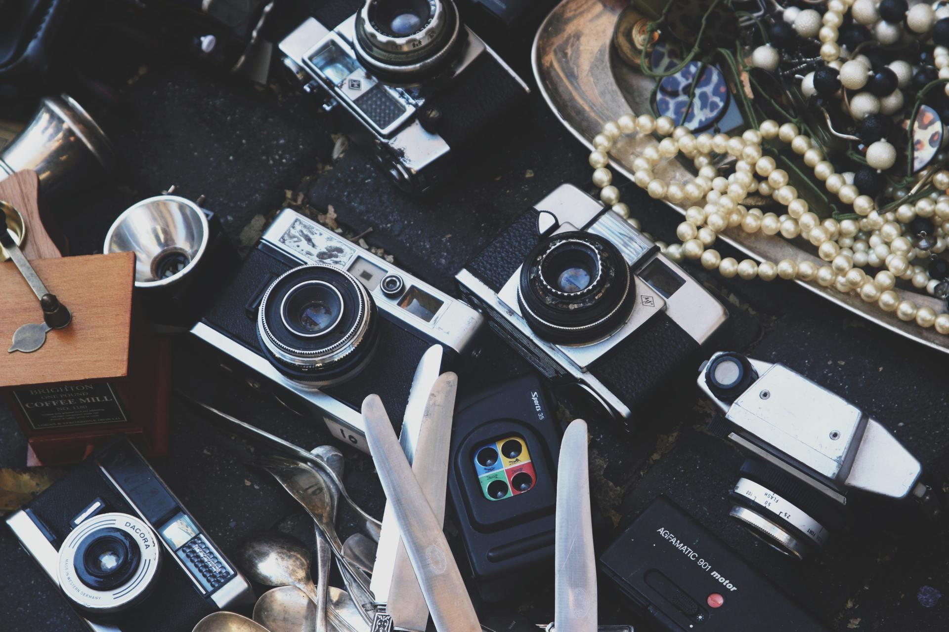 A bunch of old cameras are laying on a table