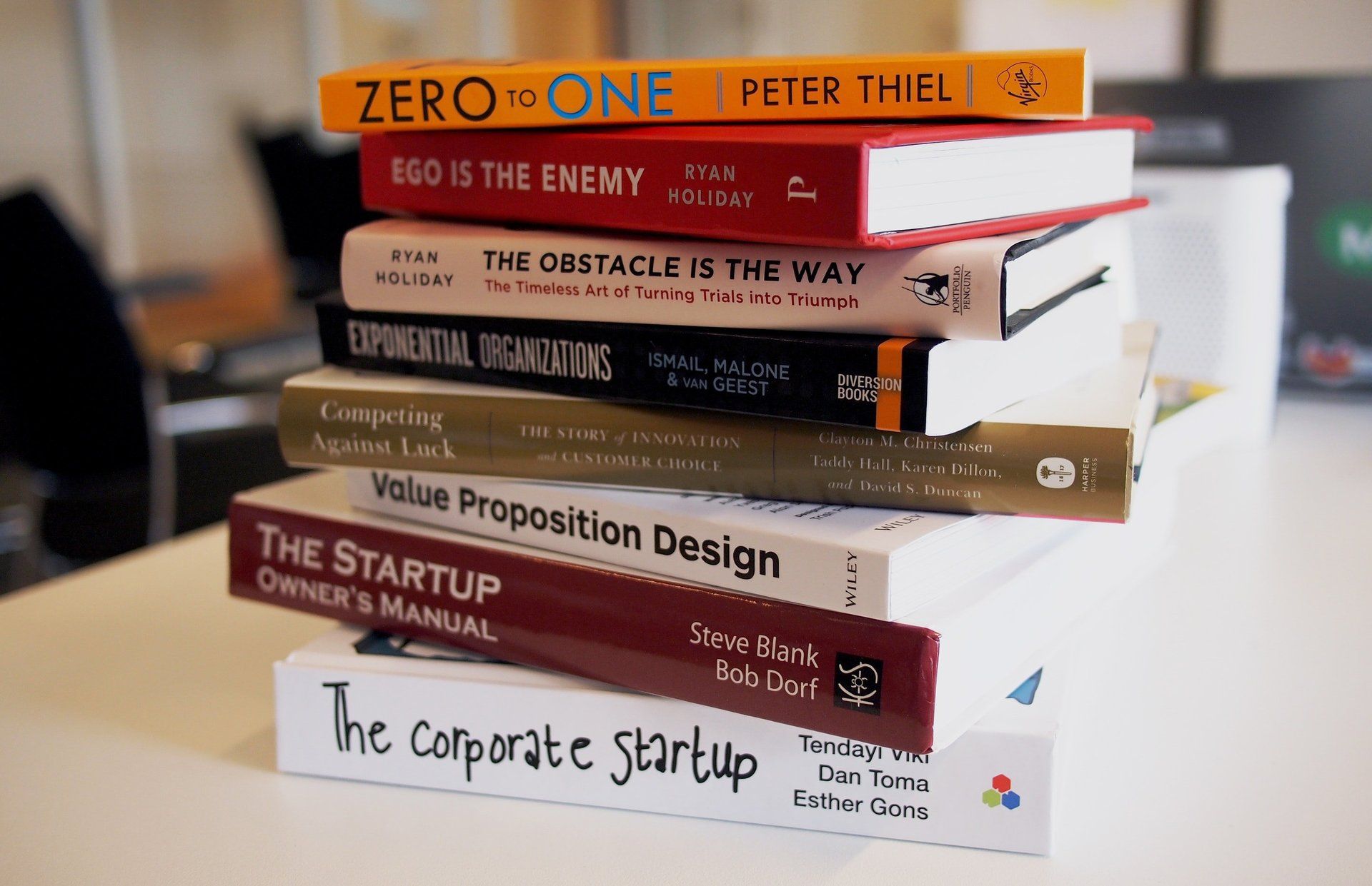 A stack of books including one titled zero to one