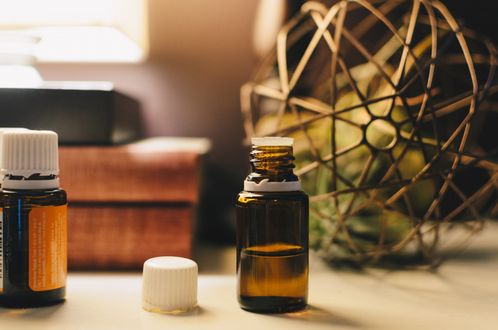 Three bottles of essential oils are sitting on a table.