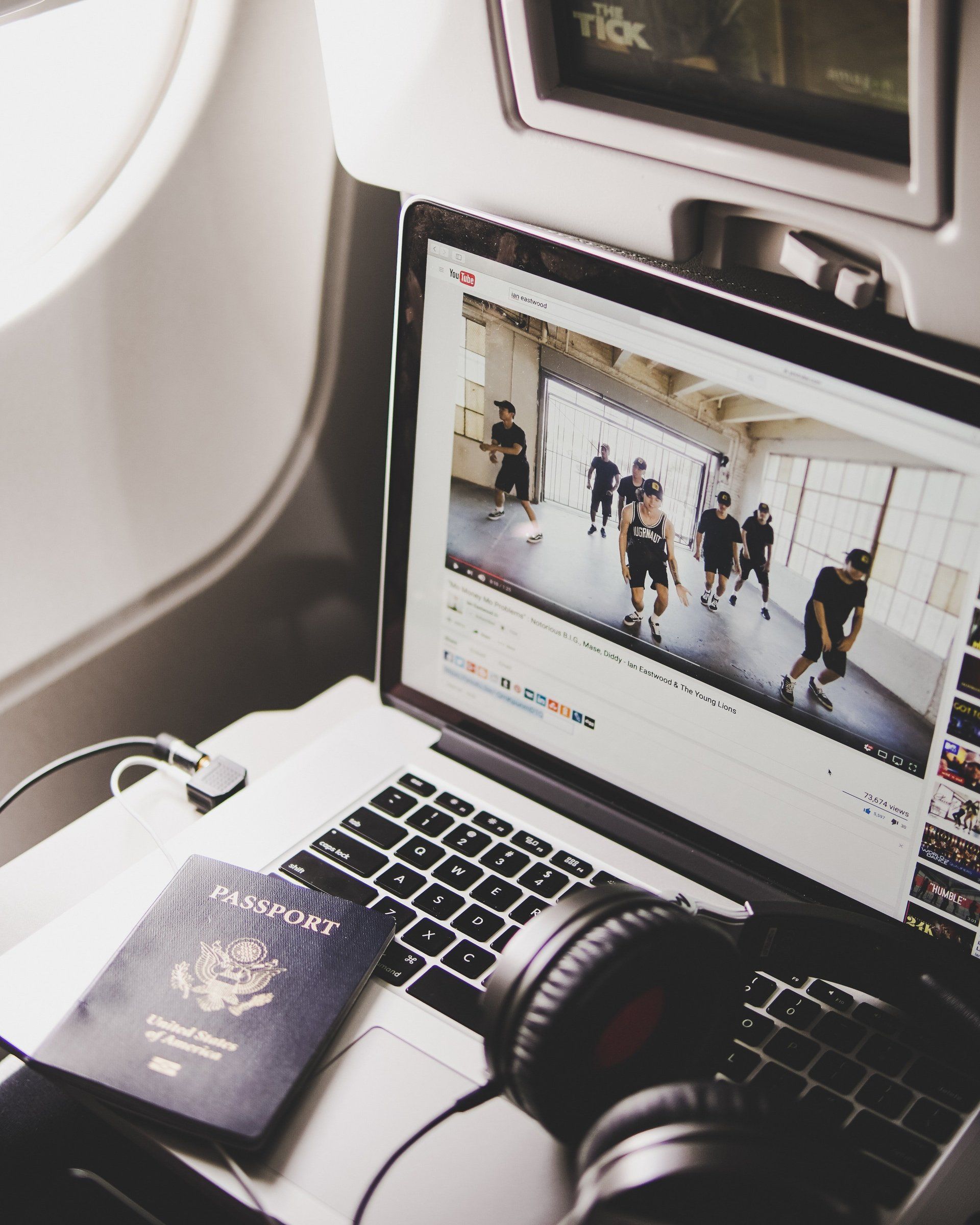a laptop with a passport and headphones on it