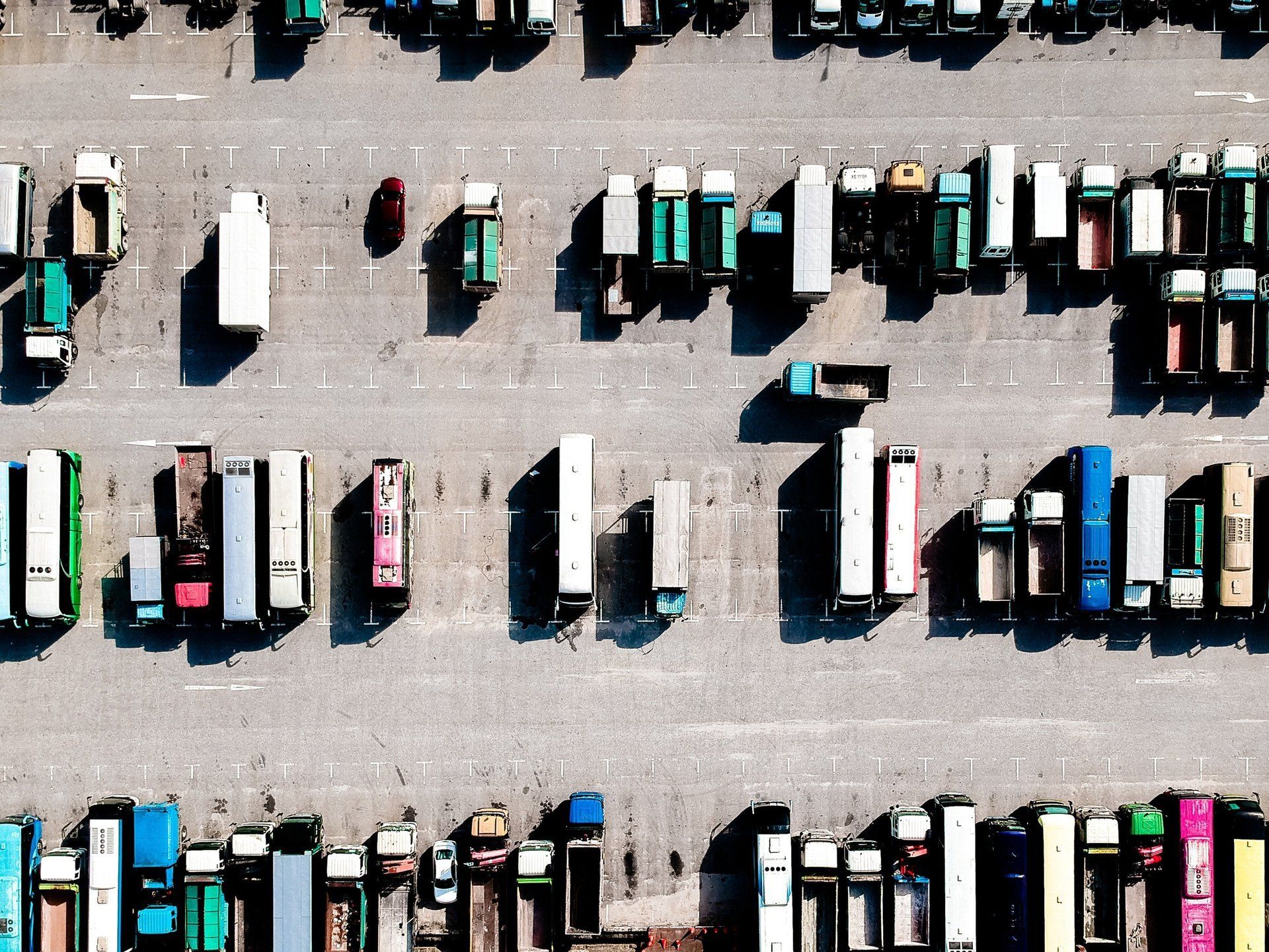 An aerial view of a parking lot filled with lots of trucks.