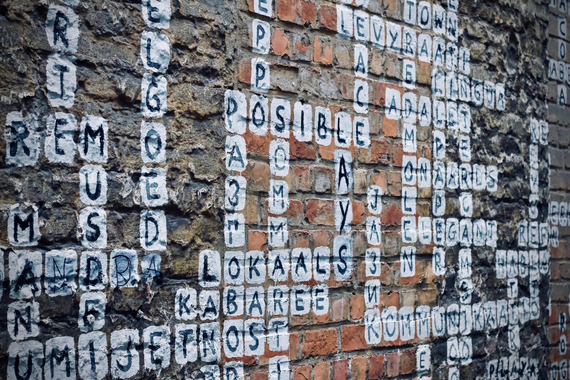 A brick wall with a lot of letters on it