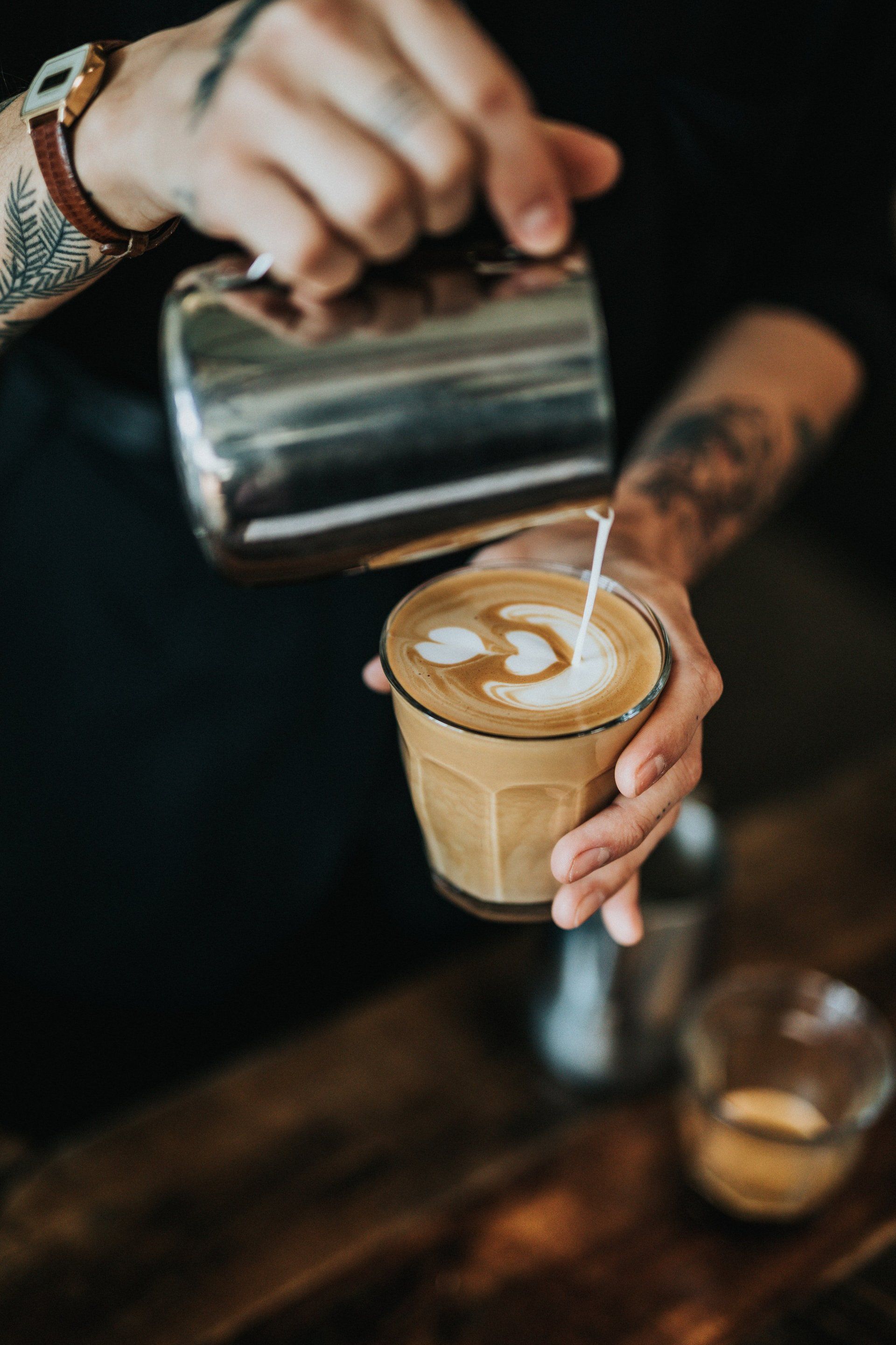 A person is pouring milk into a cup of coffee
