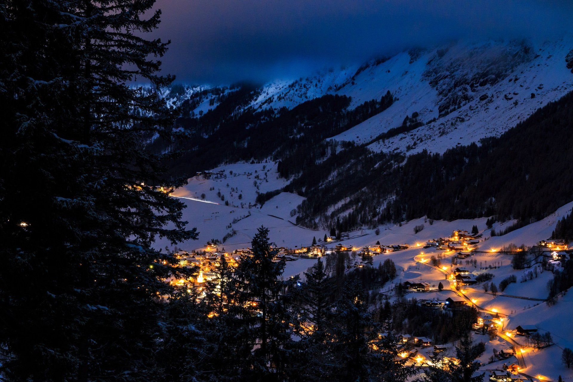 Ein Dorf in den Bergen ist nachts beleuchtet
