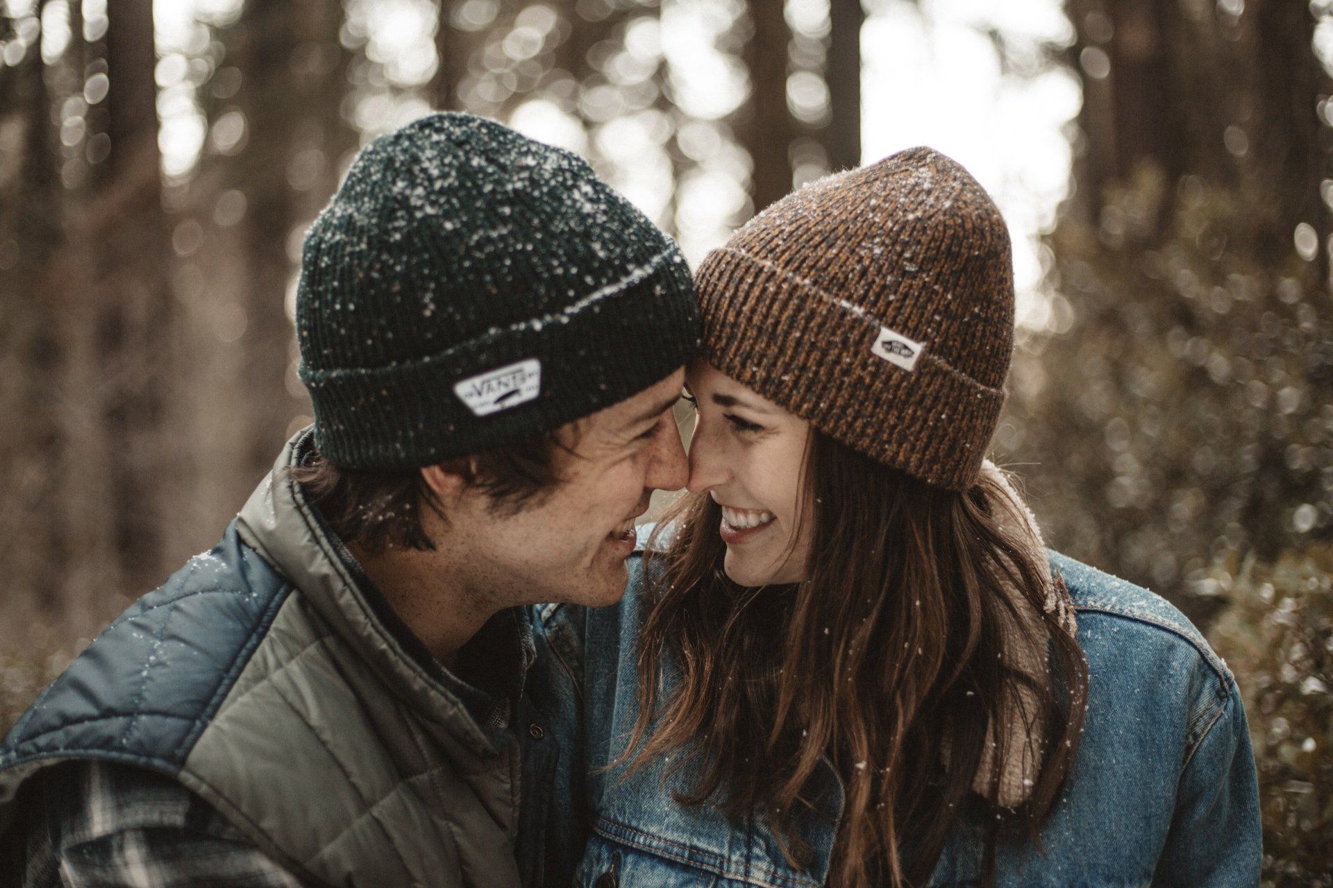 A man and a woman are looking at each other in the woods.