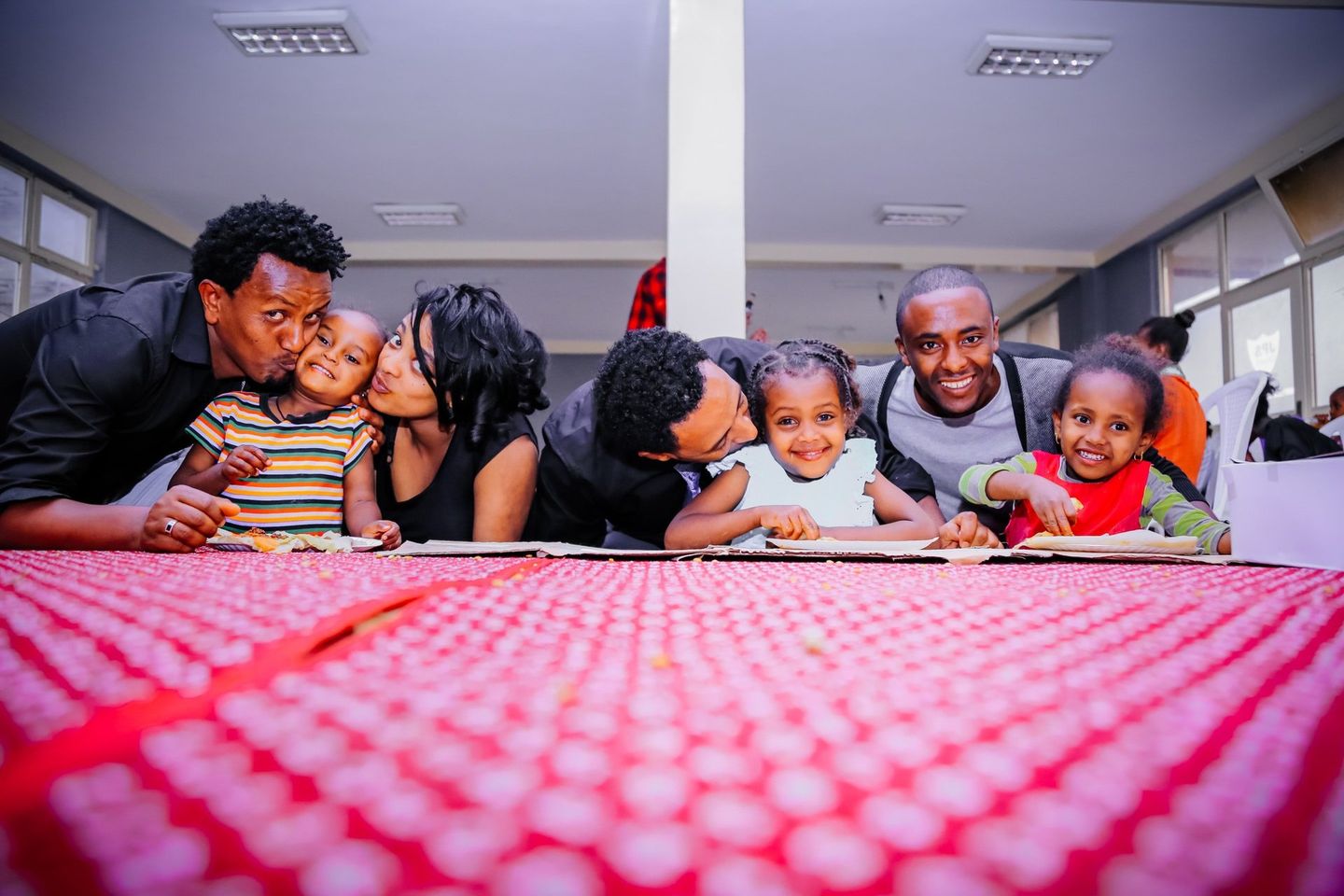 A family is posing for a picture while laying on a table.