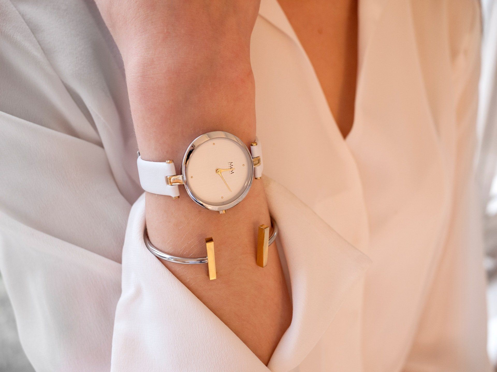 Een vrouw die een horloge en een armband om haar pols draagt.