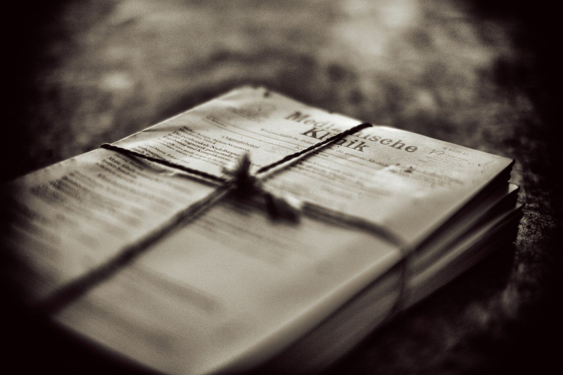 A black and white photo of a stack of papers tied together