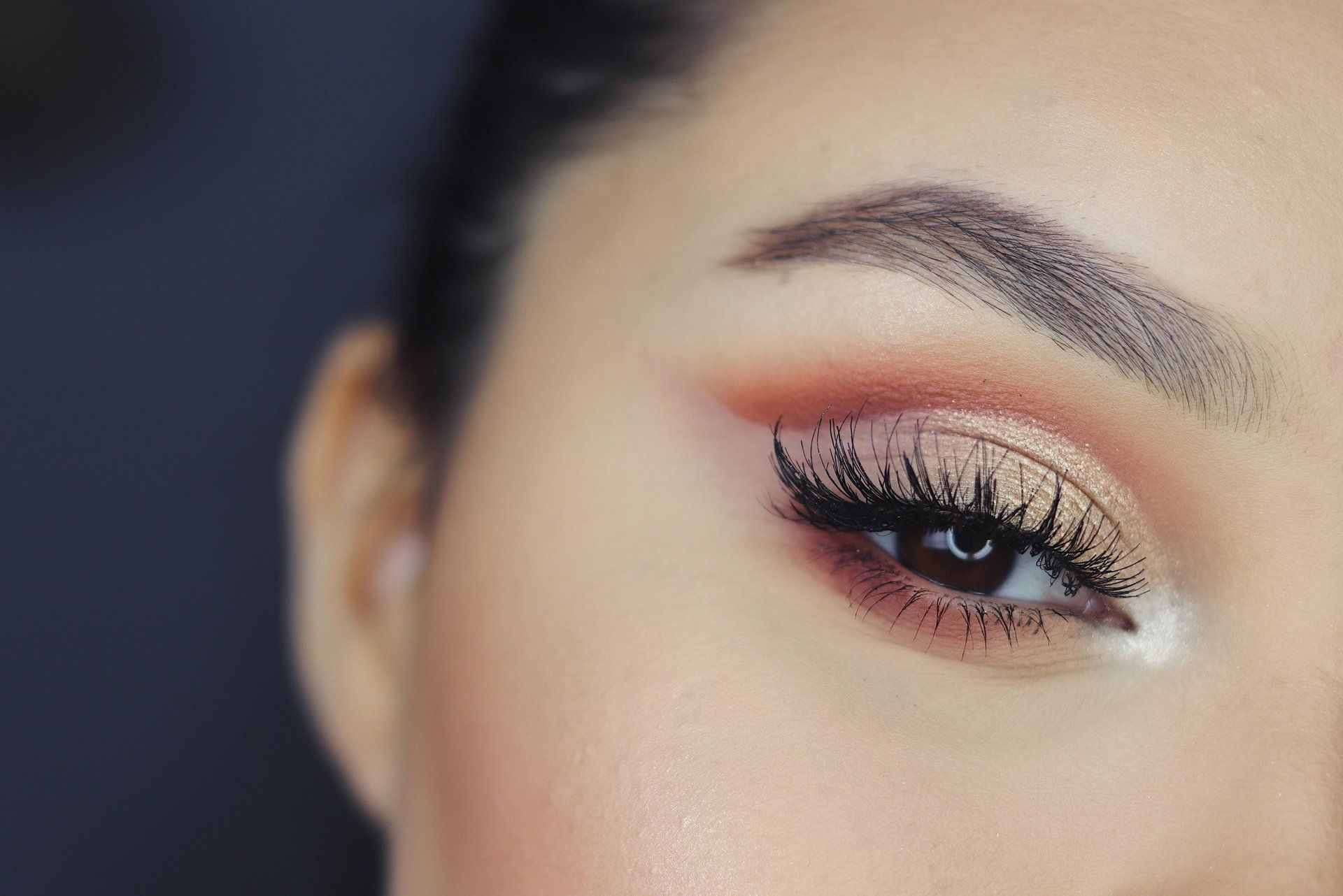 A close up of a woman 's eyelashes with makeup on.