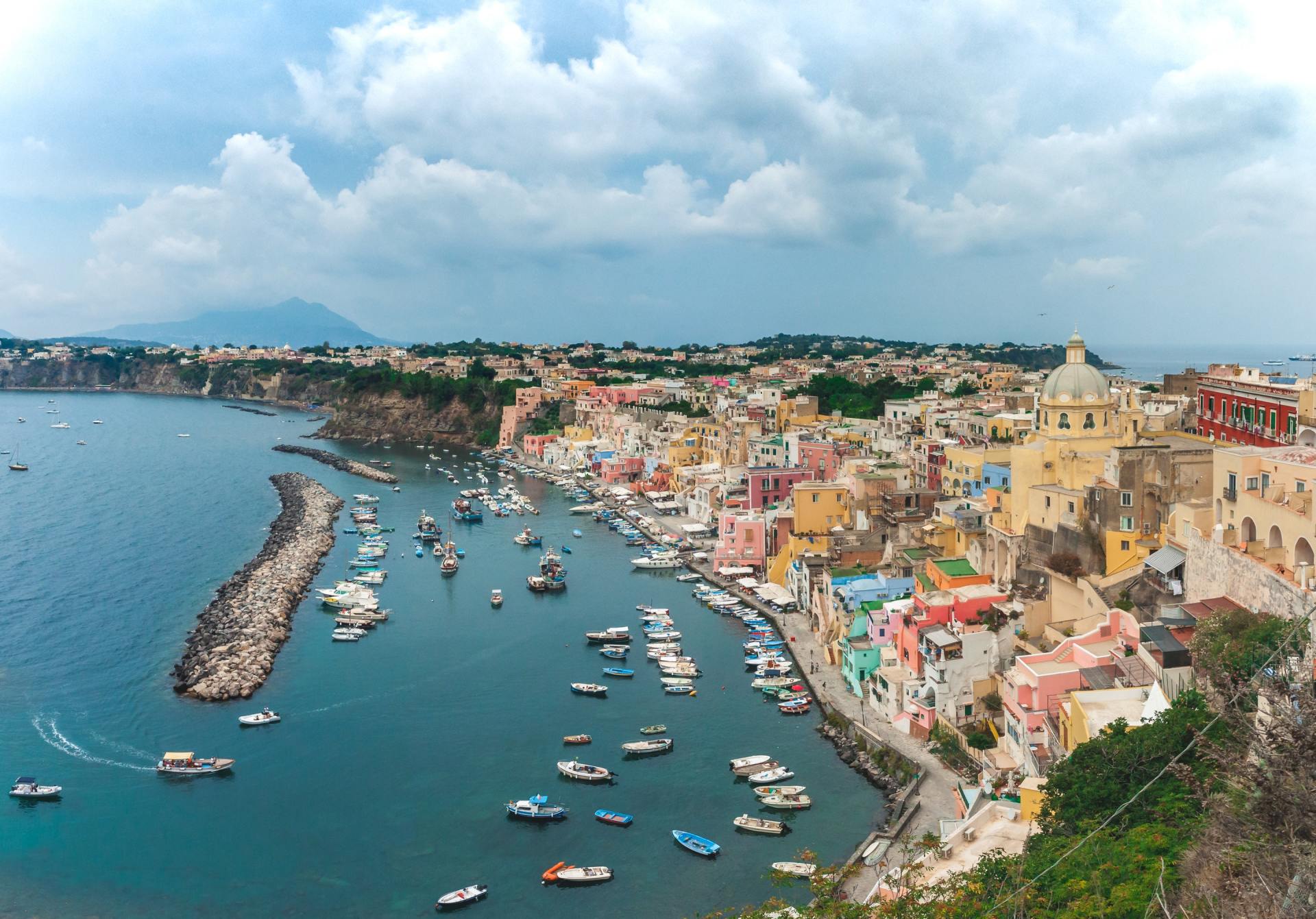 A large body of water with boats in it and a city in the background.