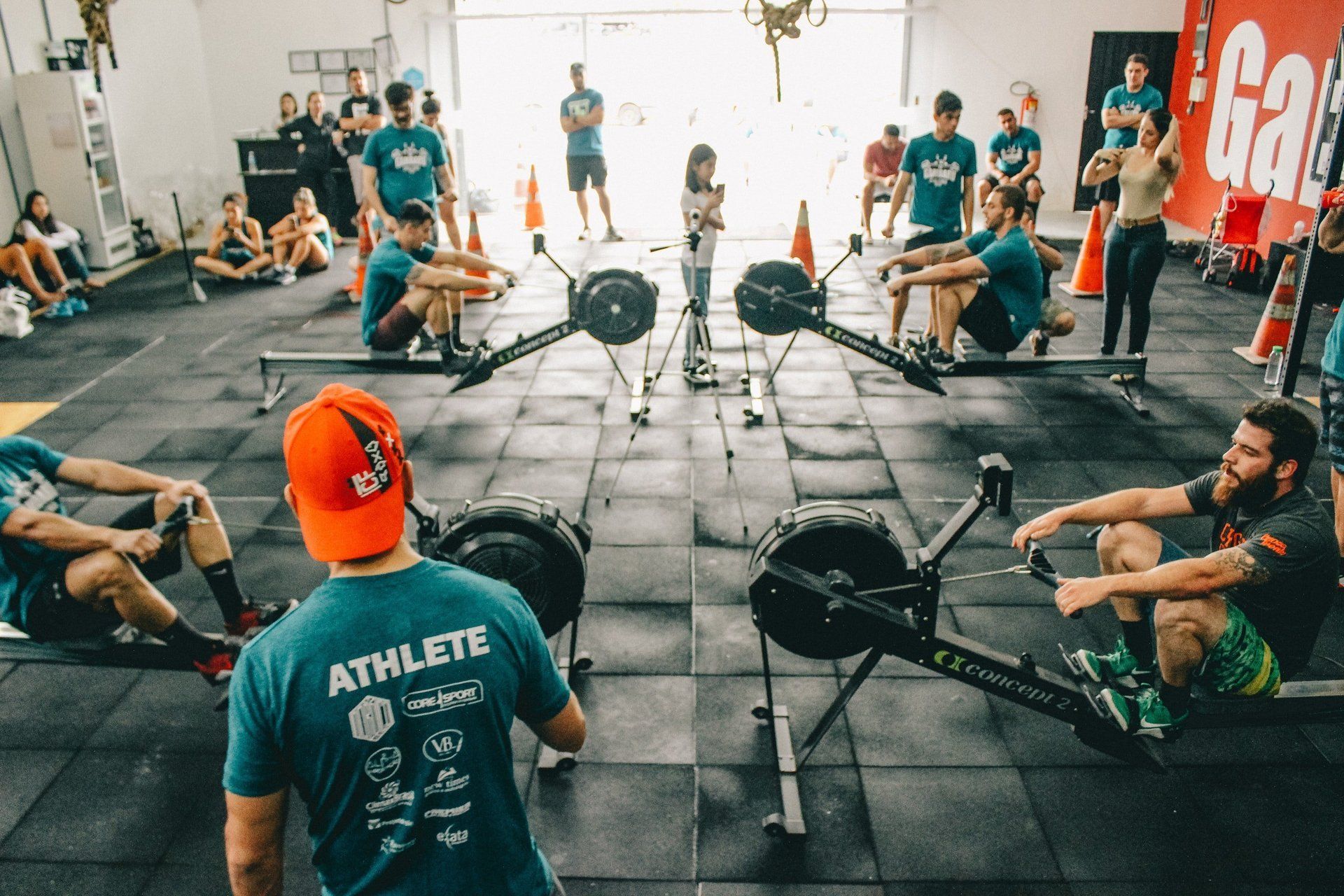 Eine Gruppe von Menschen rudert in einem Fitnessstudio auf Rudergeräten.