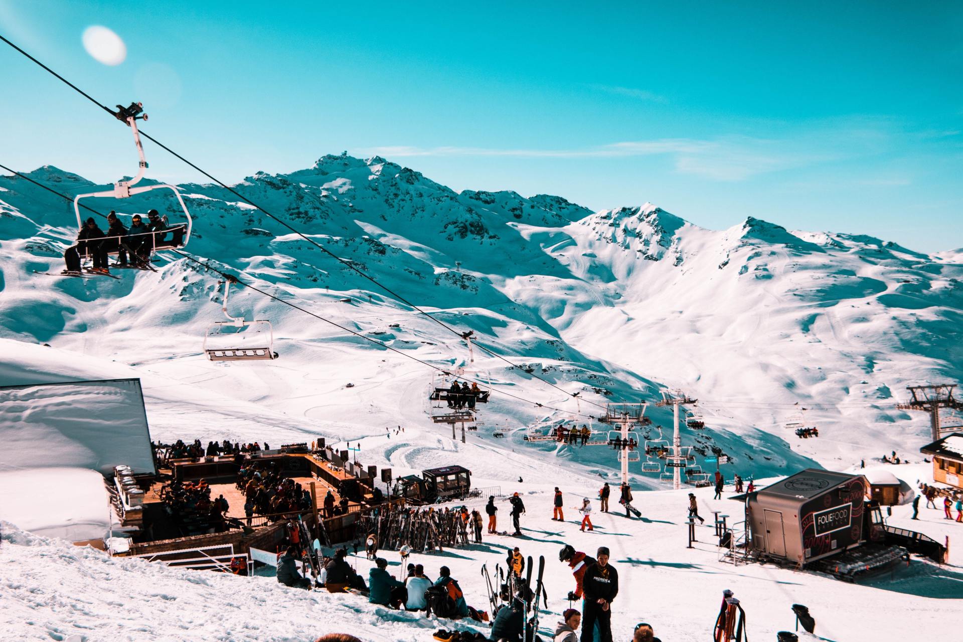 A group of people are riding a ski lift on top of a snow covered mountain.
