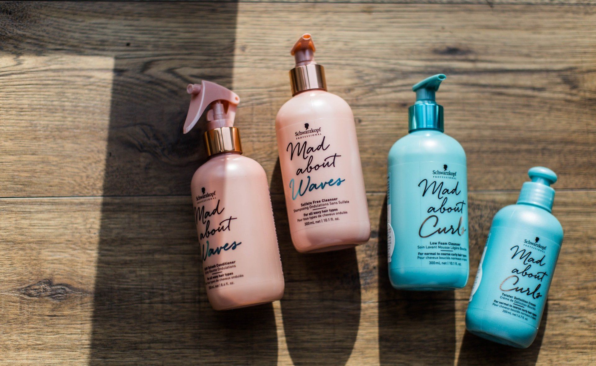 Four bottles of hair products are sitting on a wooden table
