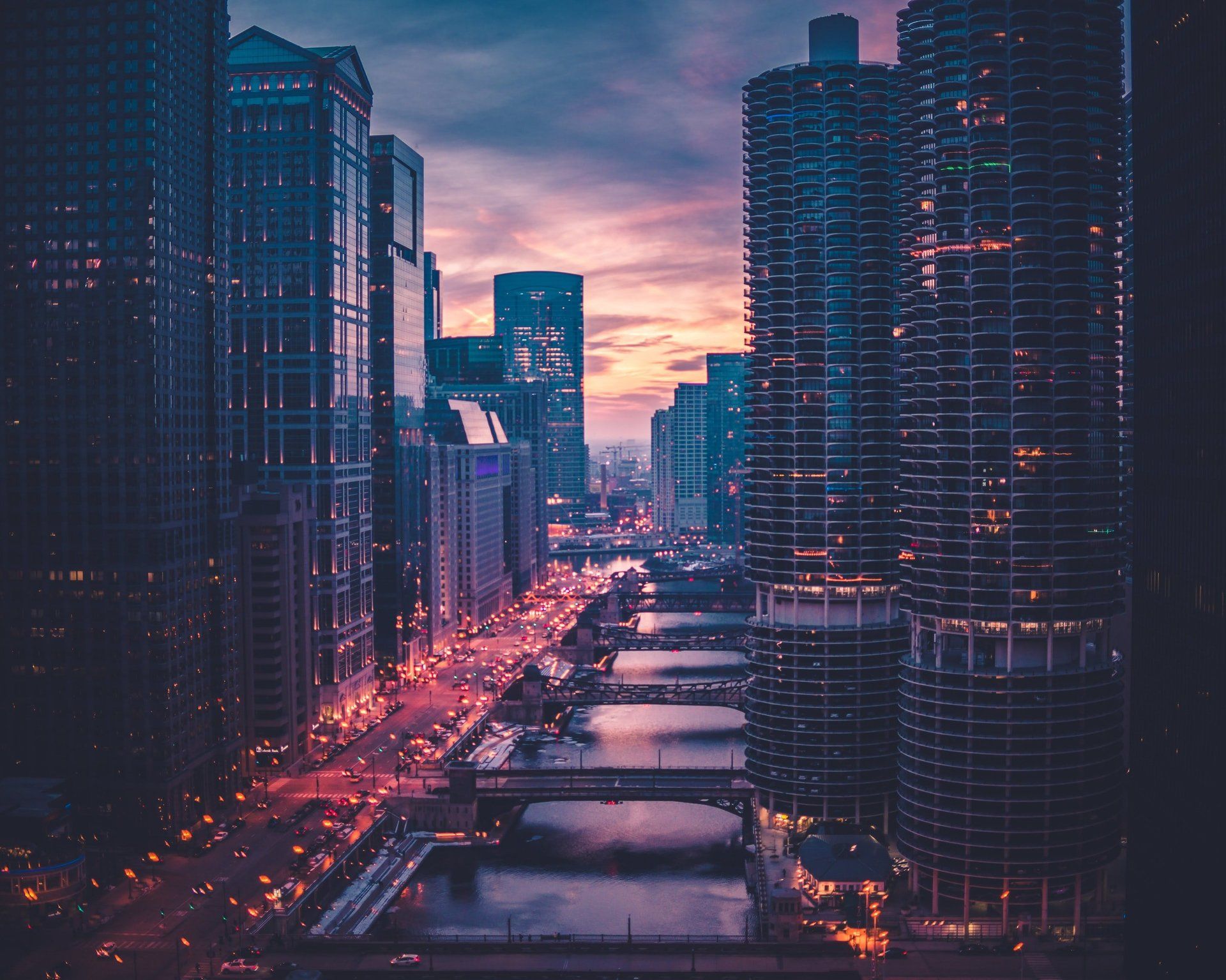 An aerial view of a city at night with a river in the foreground.