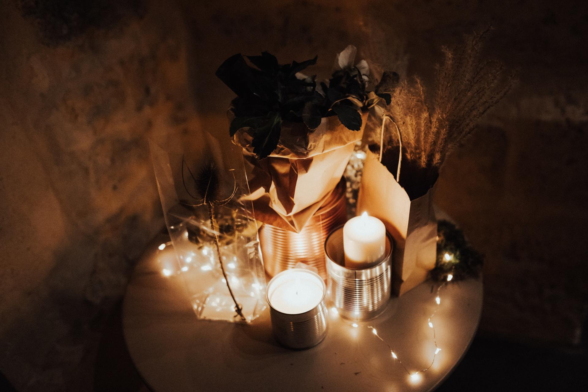 A table with candles and flowers on it in a dark room.