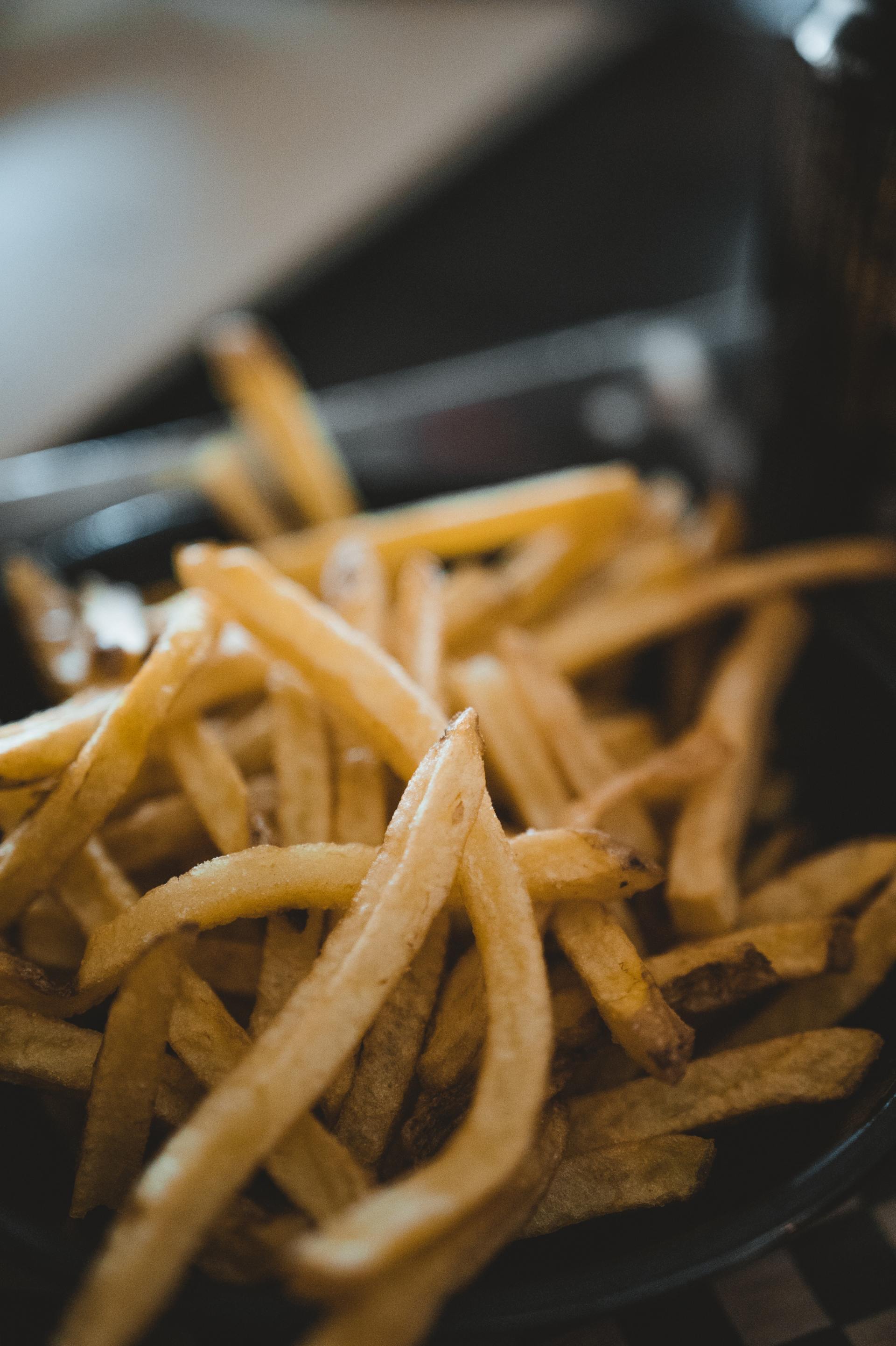A close up of french fries in a frying pan.
